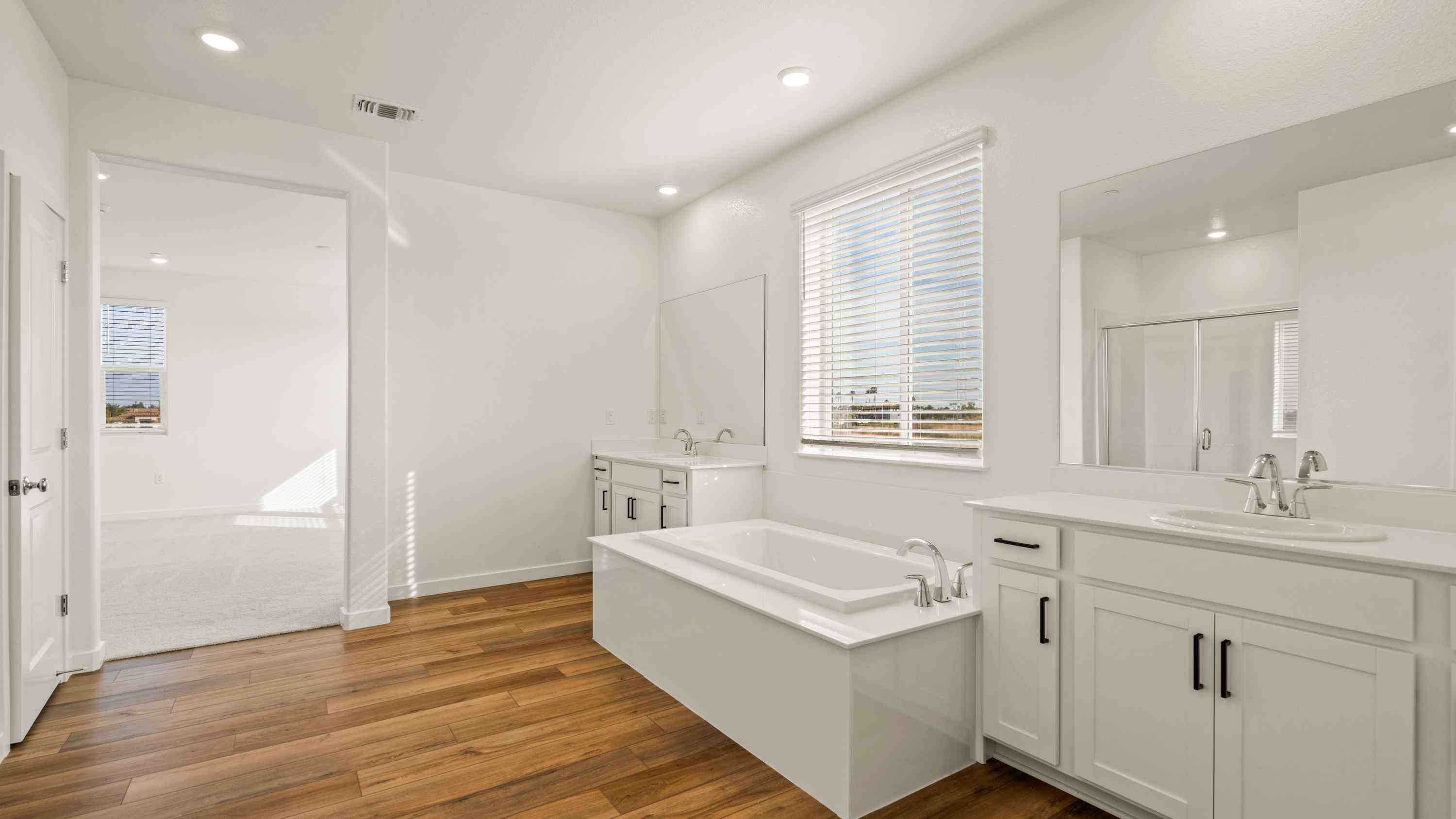 A bathroom with a tub sink and a mirror.