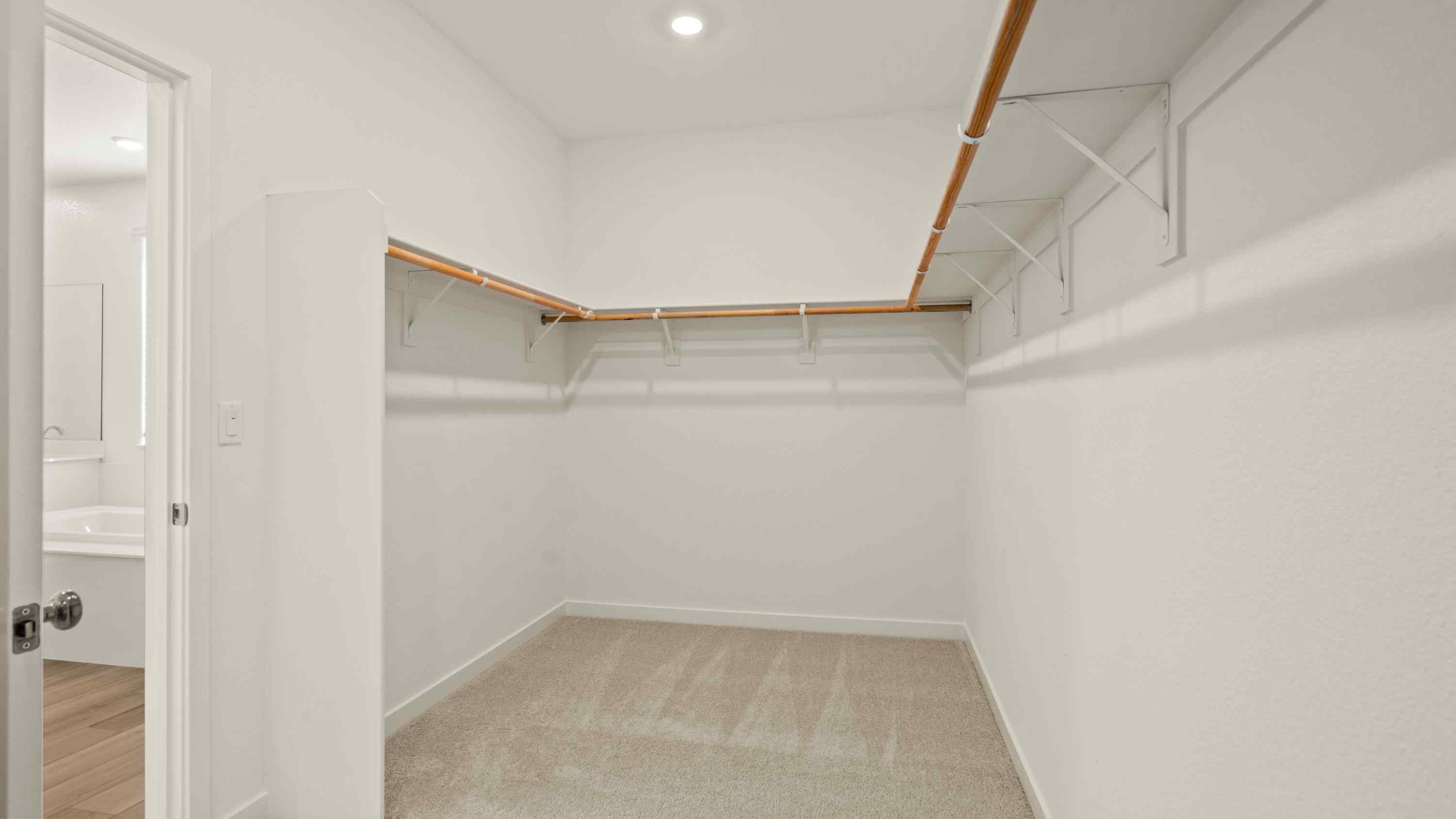 A white room with a white wall and a wood ladder.