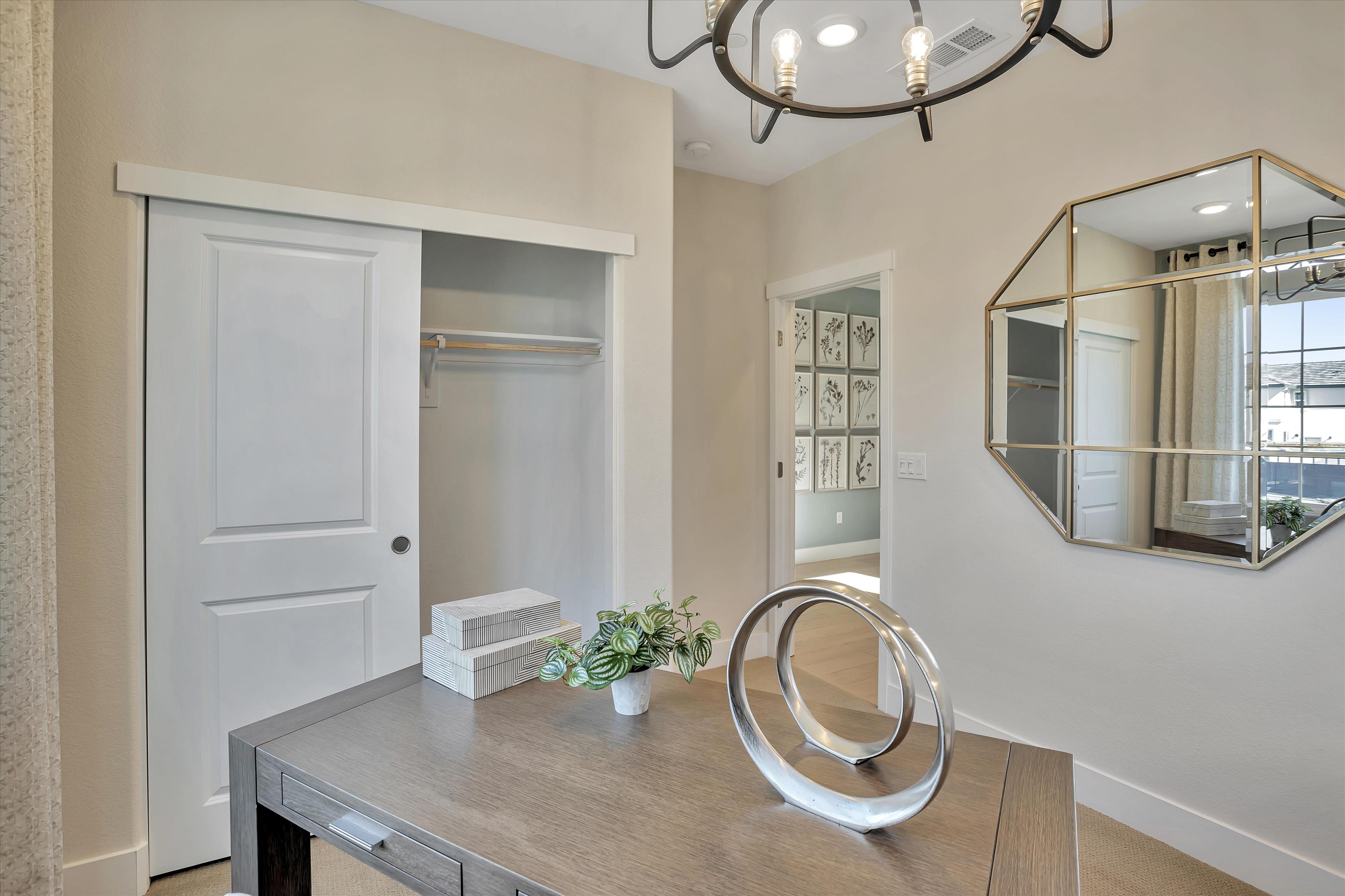 A room with a round table and a mirror.