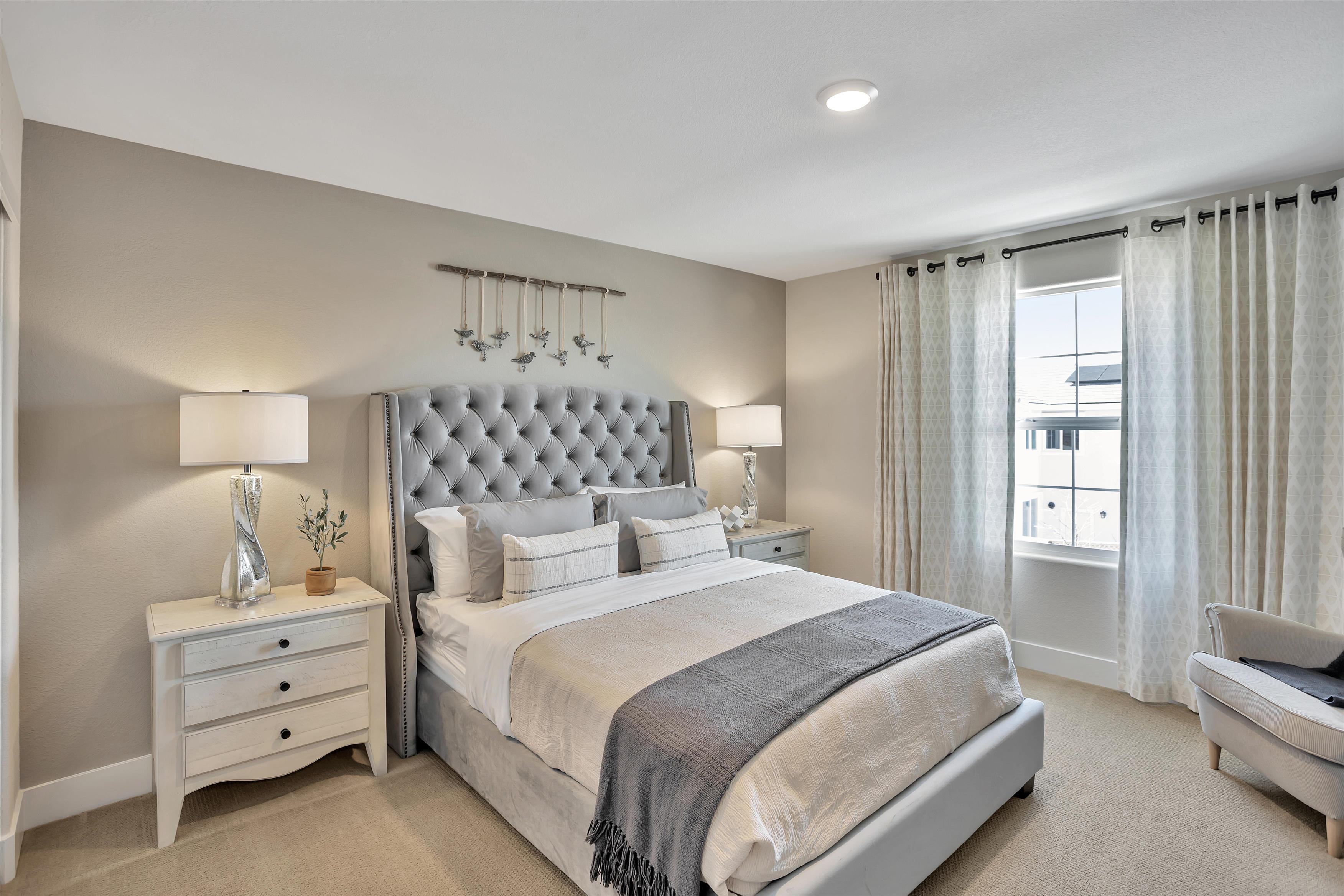 A bedroom with a bed and a chair.