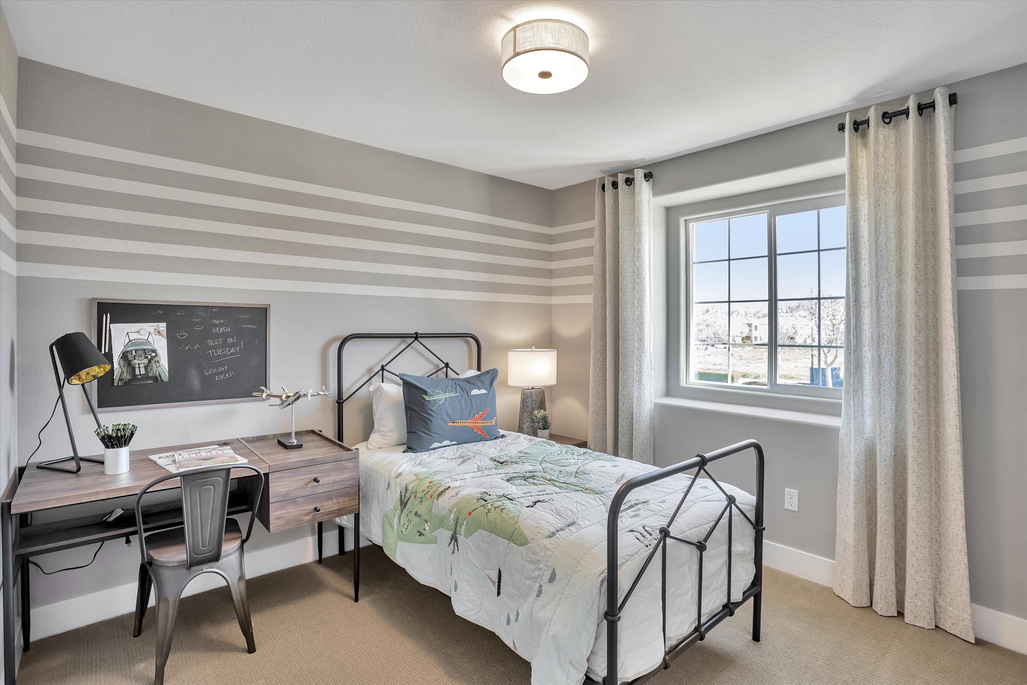 A bedroom with a bed and desk.