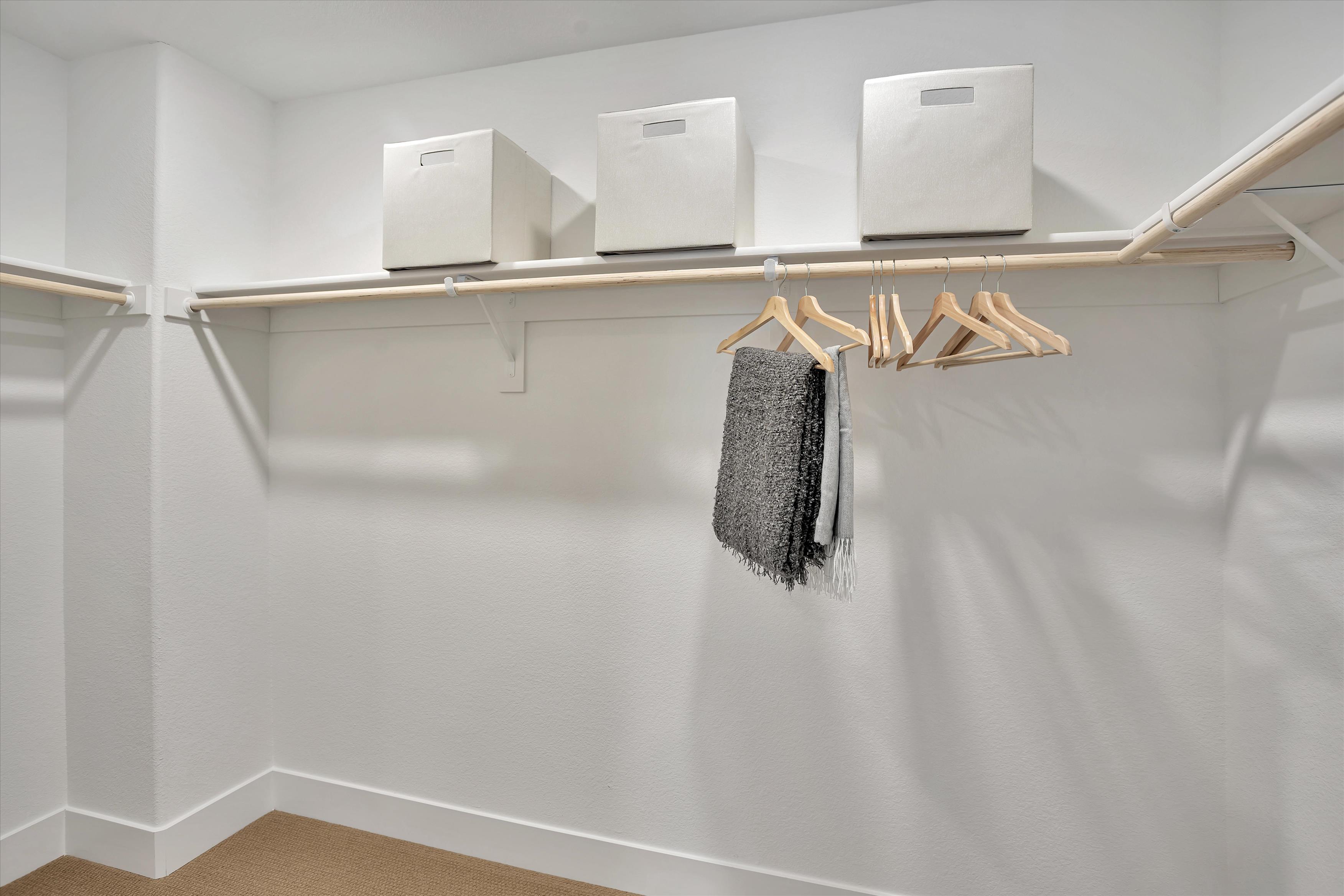 A white shelf with white boxes on it.