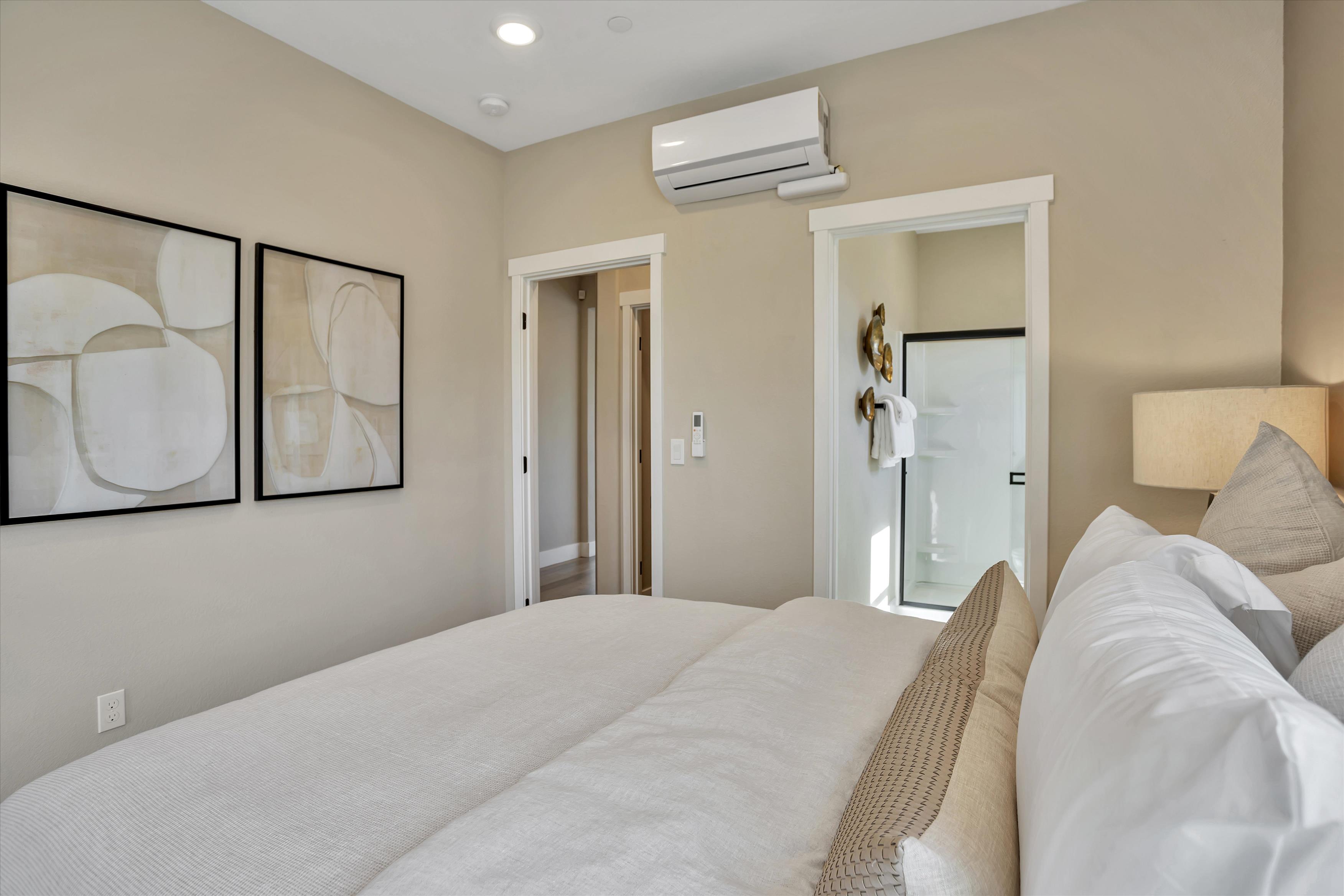 A bedroom with a bed and a mirror.