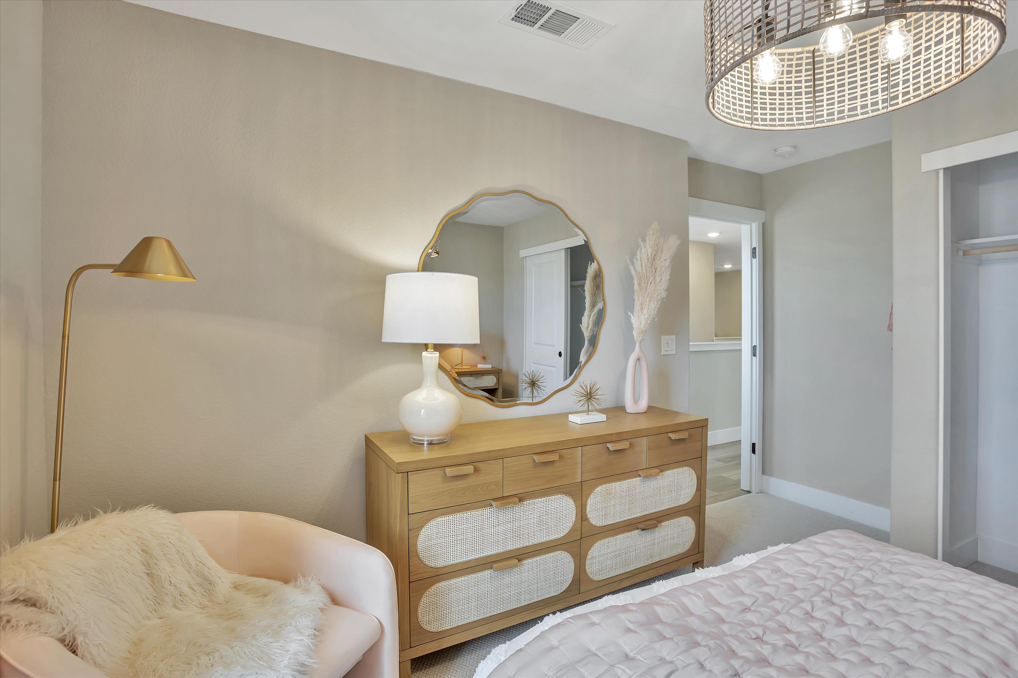 A bedroom with a mirror and a bed.