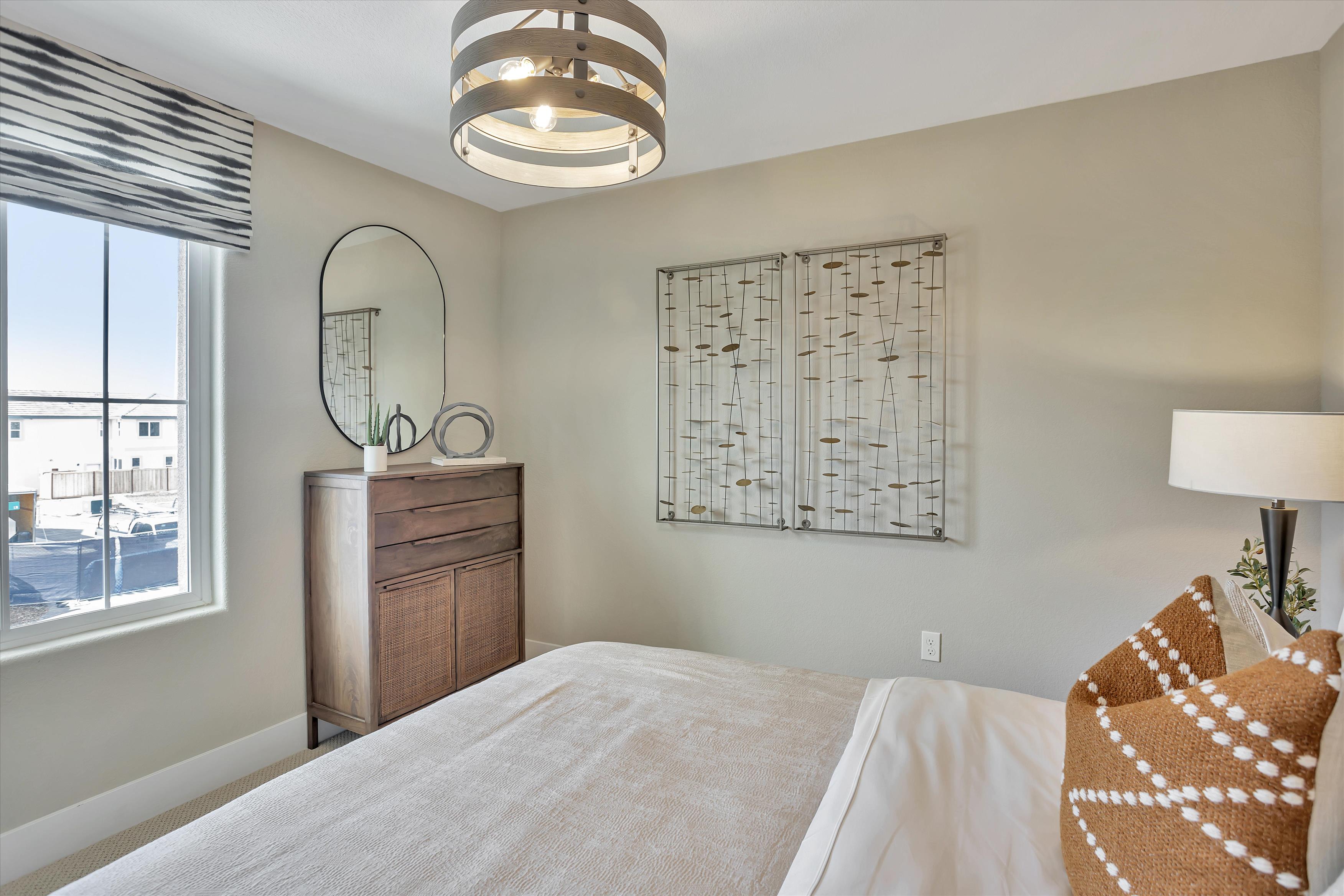 A bedroom with a large mirror.