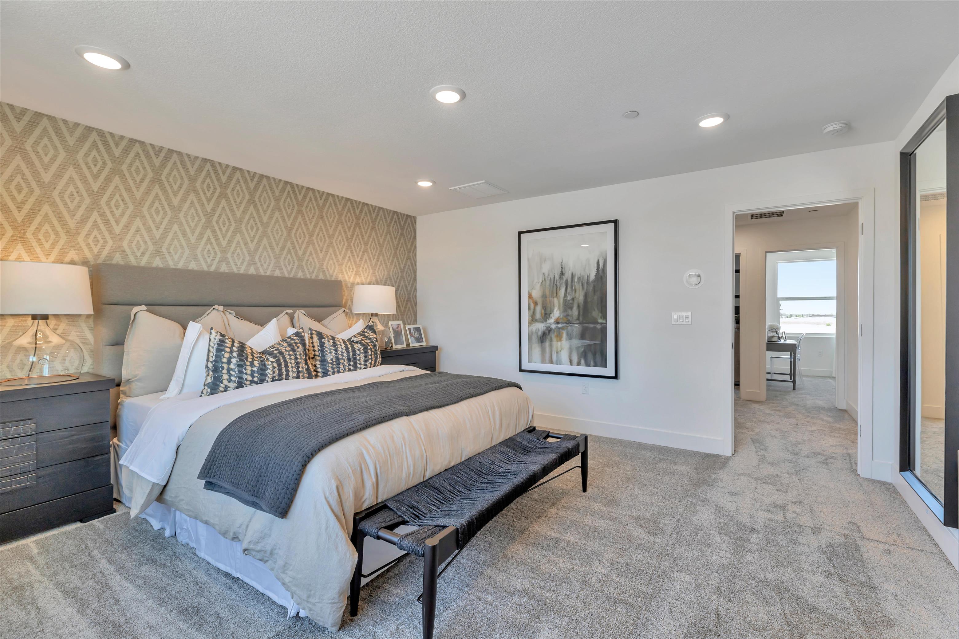 A bedroom with a bed and a lamp.