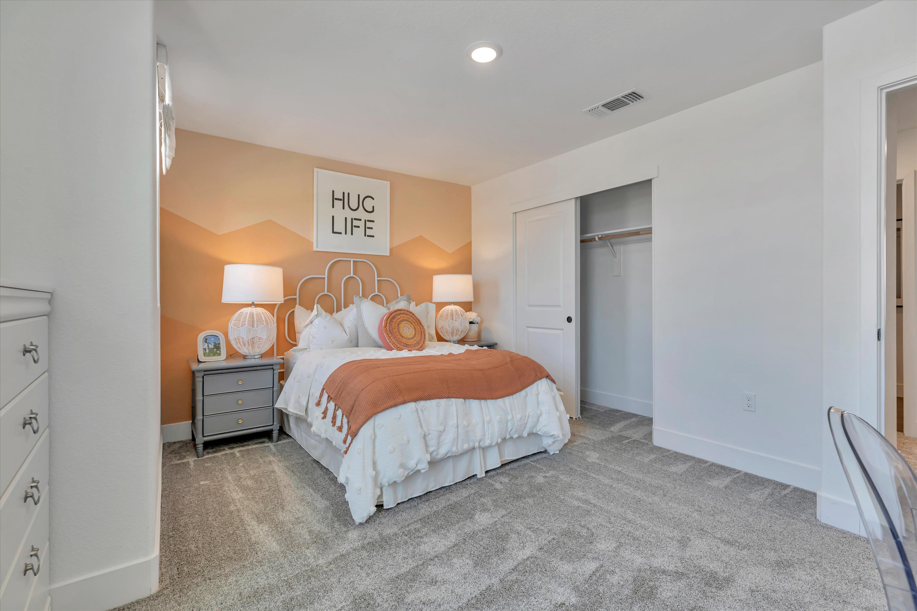 A bedroom with a bed and lamps.