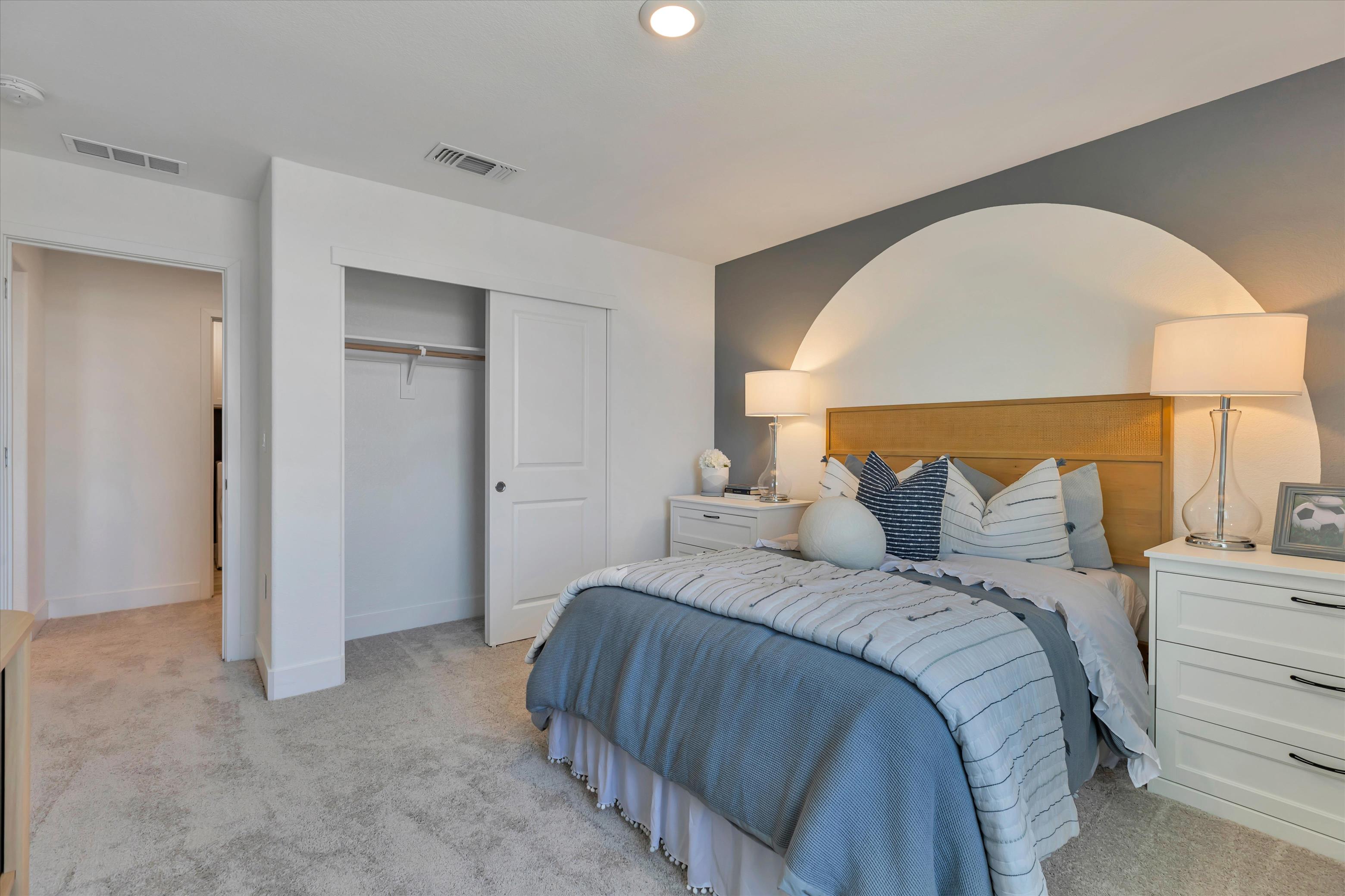A bedroom with a bed and lamps.
