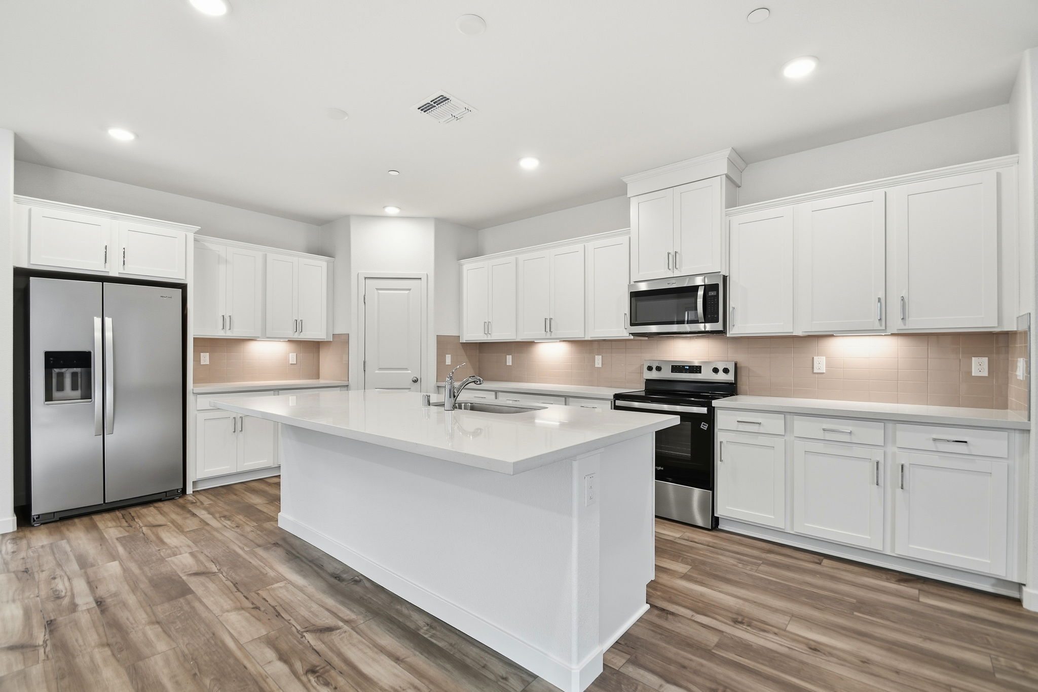 A kitchen with white cabinets.