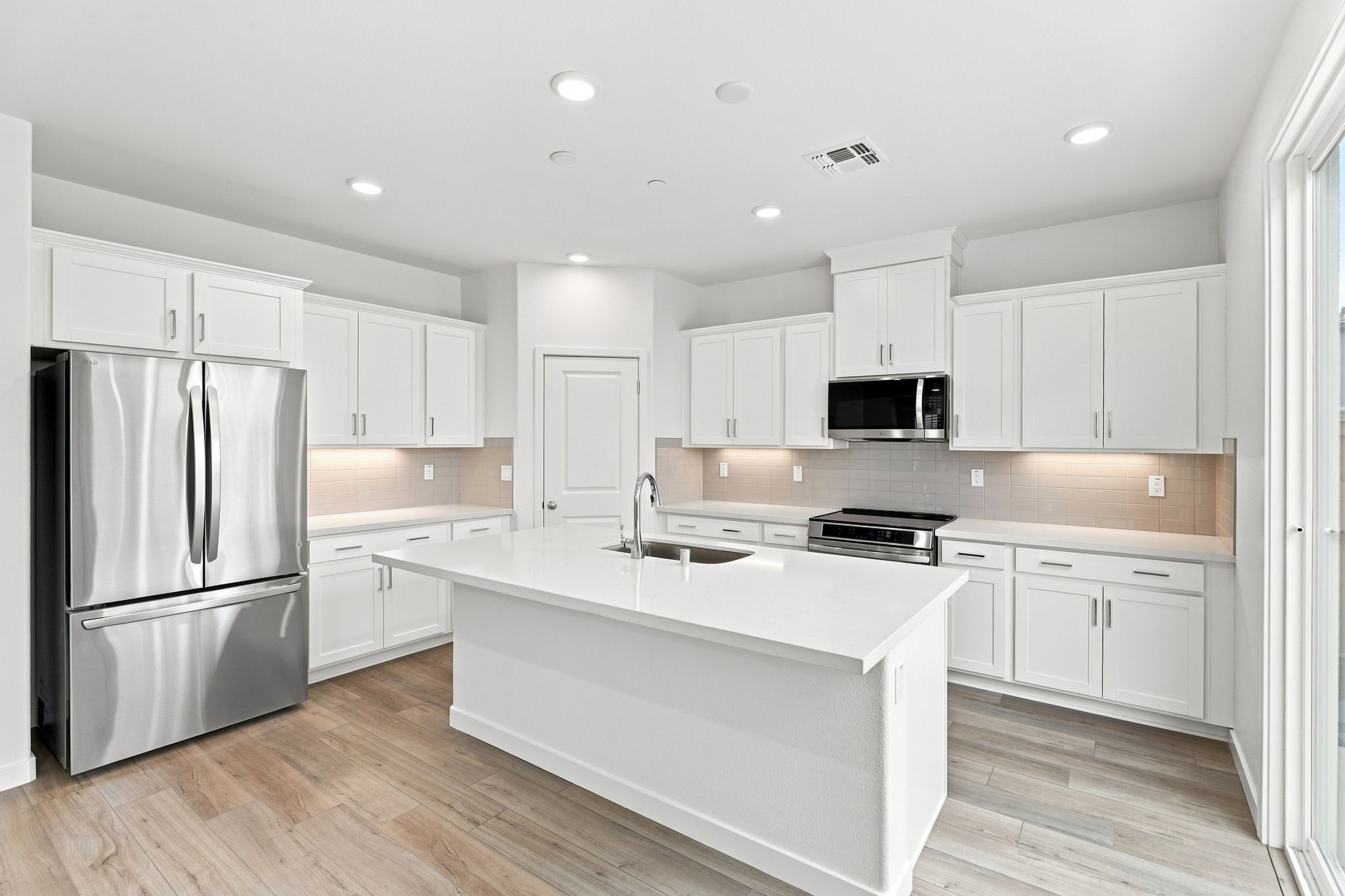 A kitchen with white cabinets.