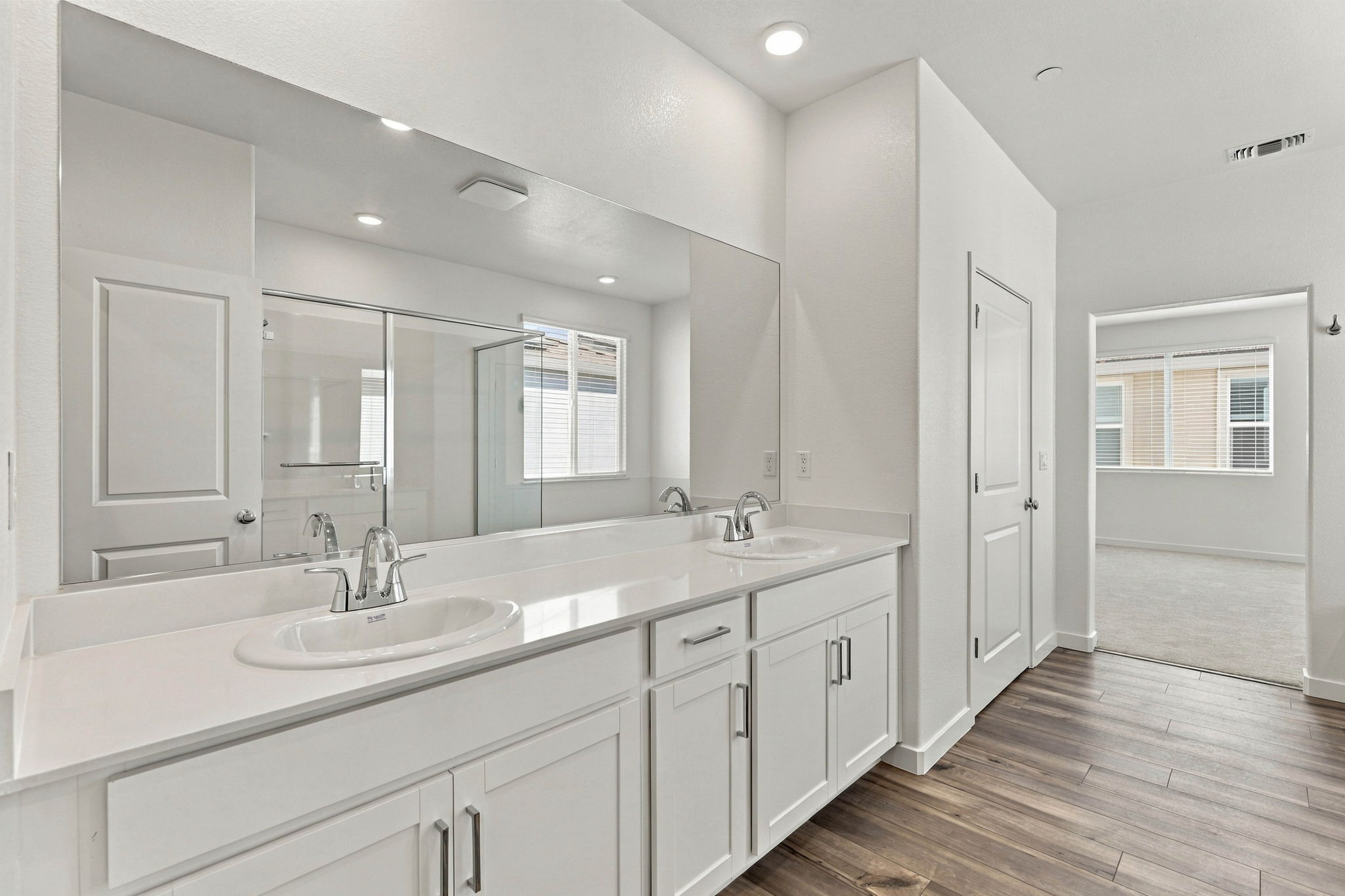 A bathroom with white cabinets.