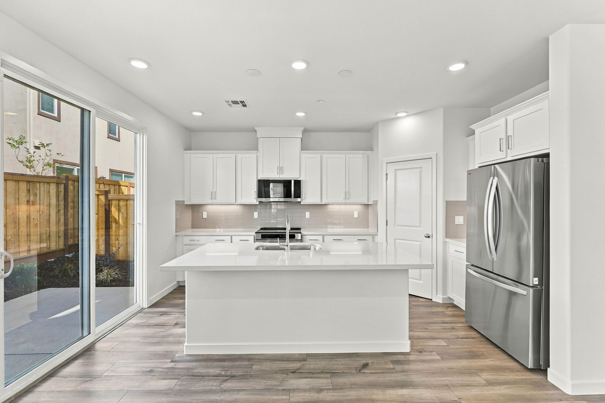 A kitchen with white cabinets.