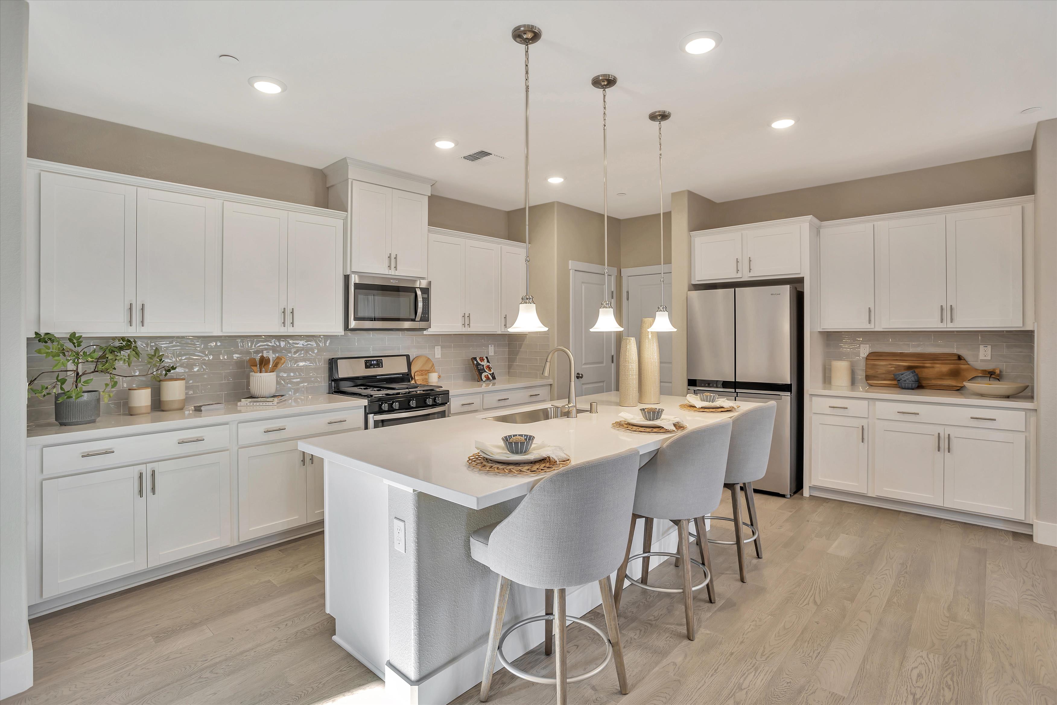 A kitchen with white cabinets.