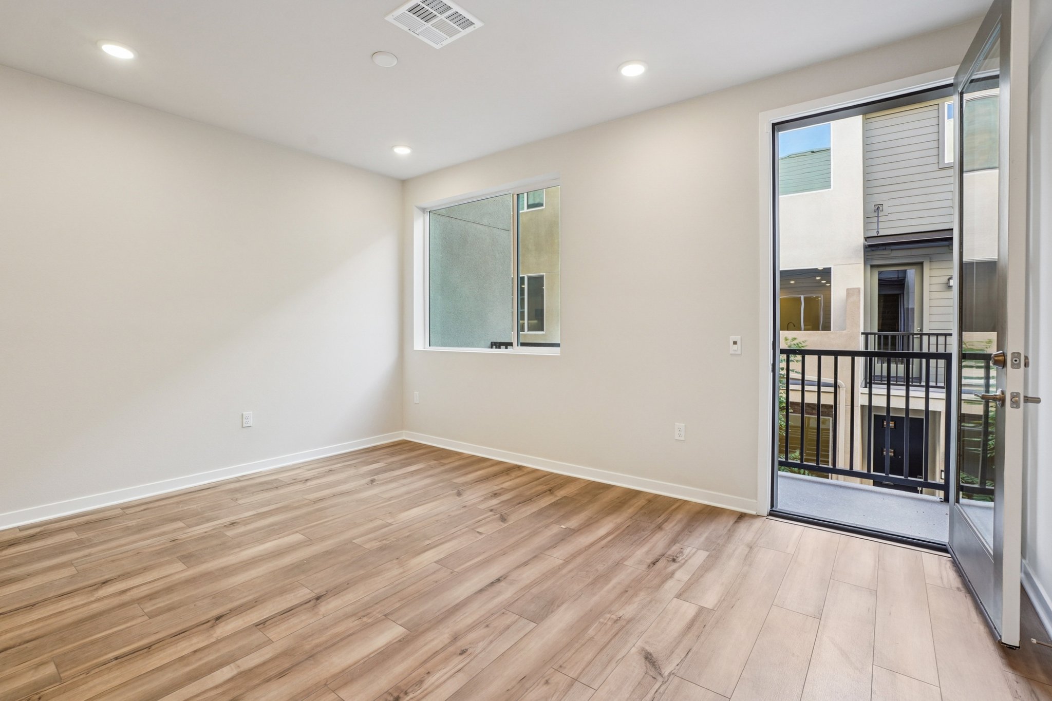 A room with a wood floor and glass doors.