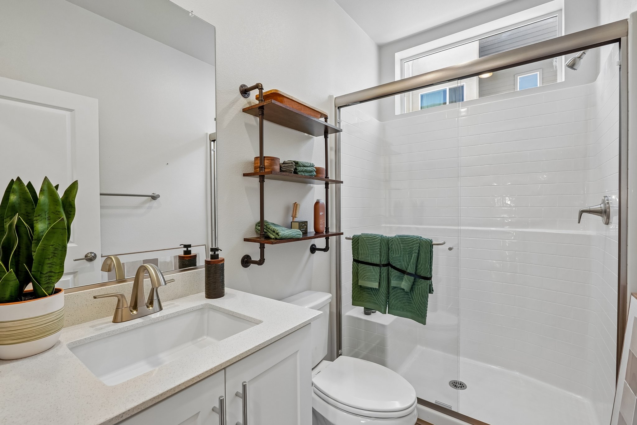 A bathroom with a sink and a shower unit.
