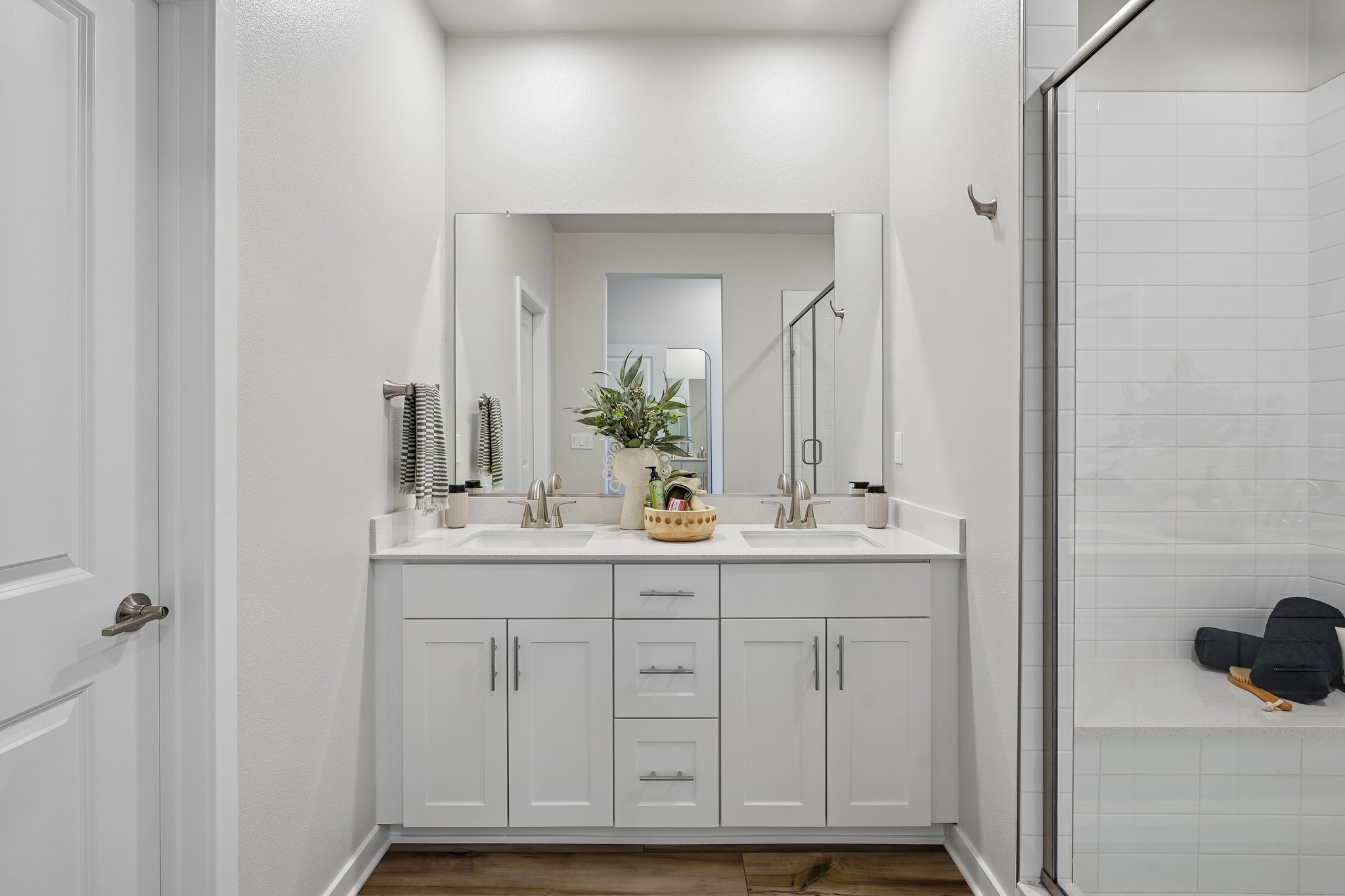 A bathroom with white cabinets.