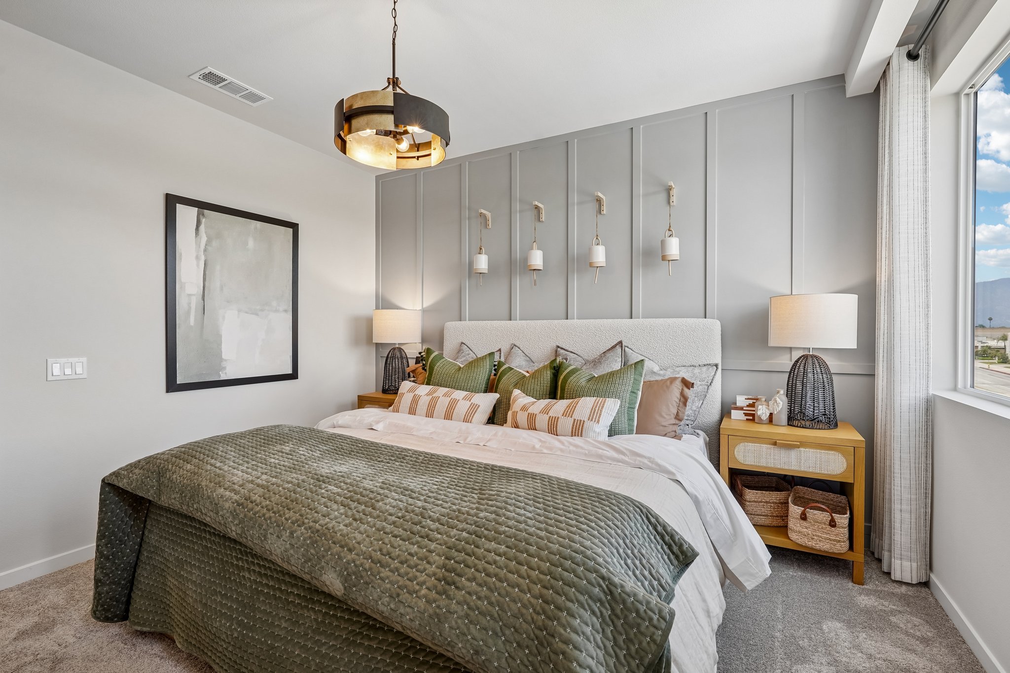 A bedroom with a bed and lamps.