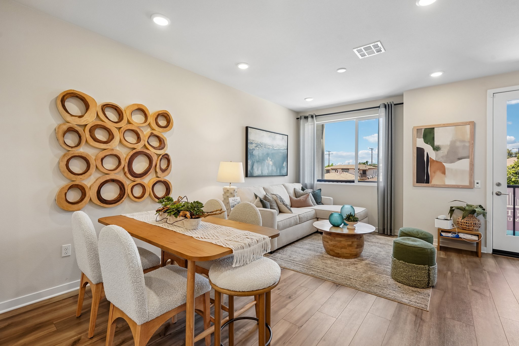 A living room with a large dining table and a large window.