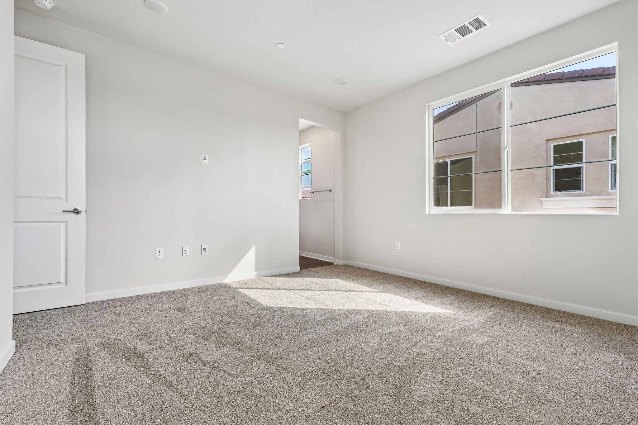 A room with a carpet and a window.