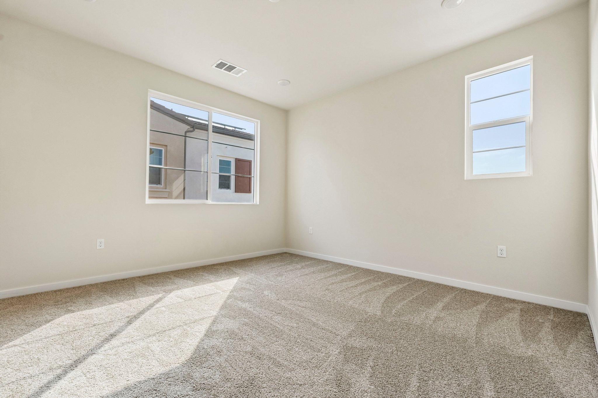 A room with a carpet and windows.
