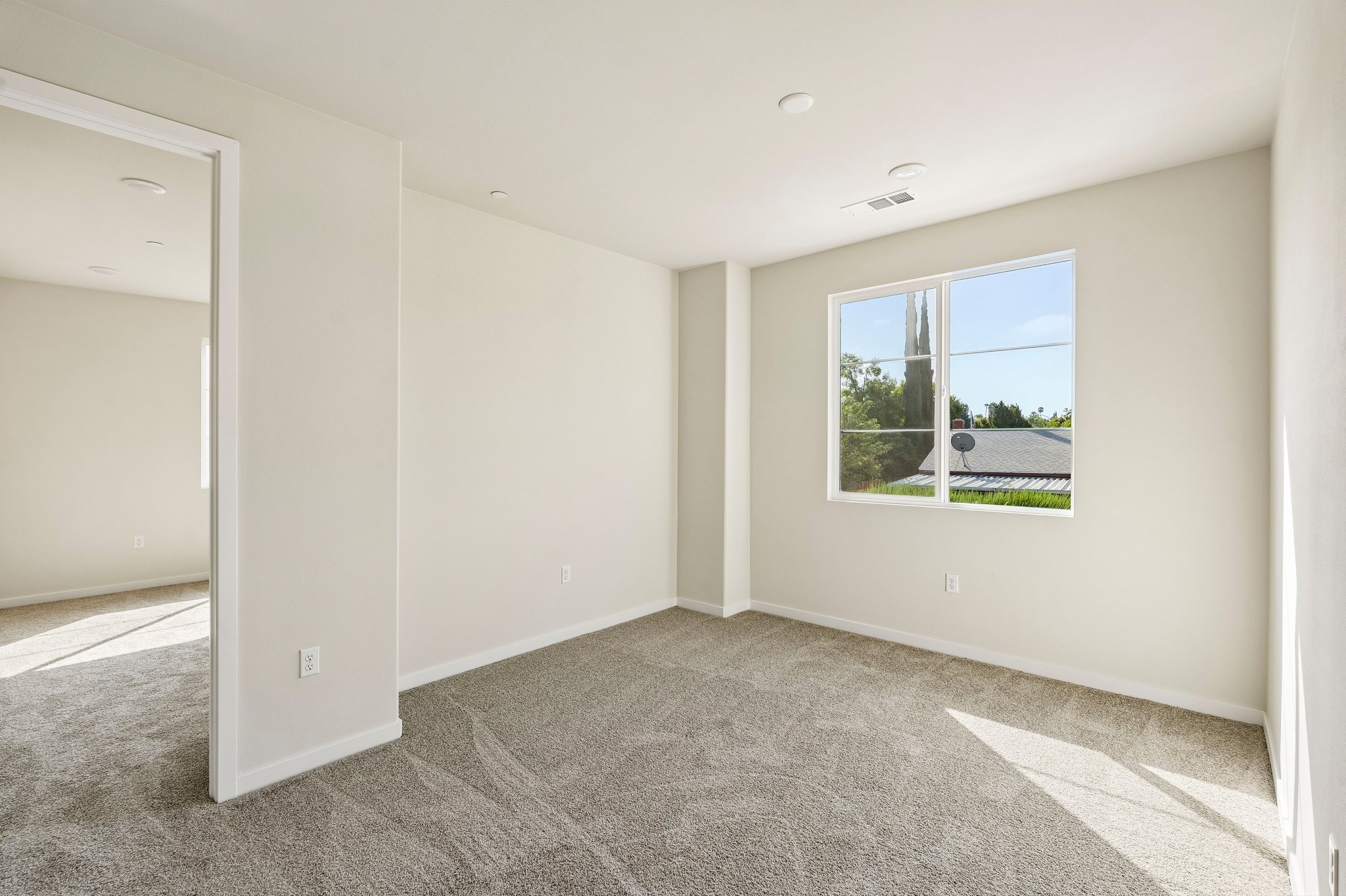 A room with a window and a carpet.