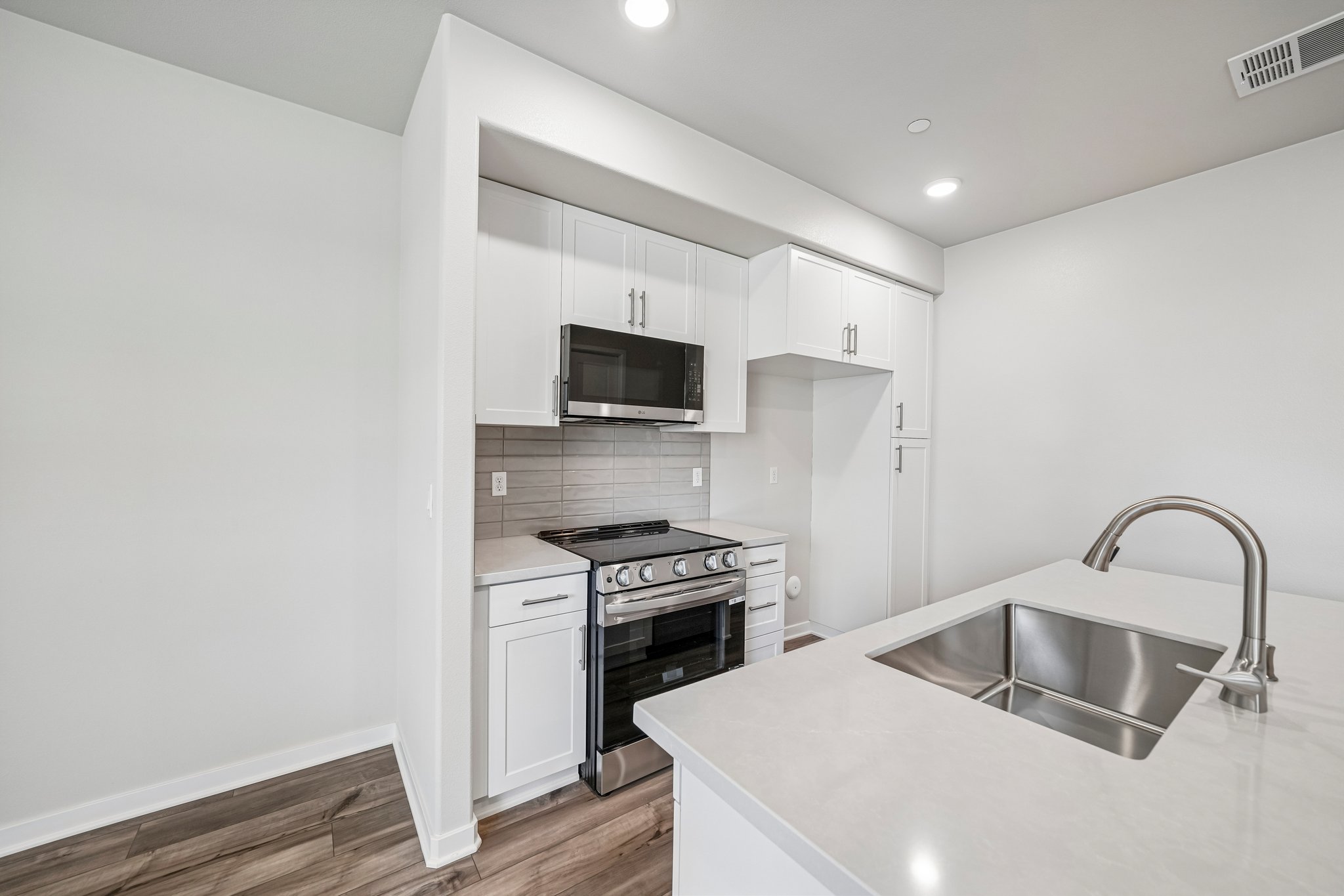 A kitchen with white cabinets.