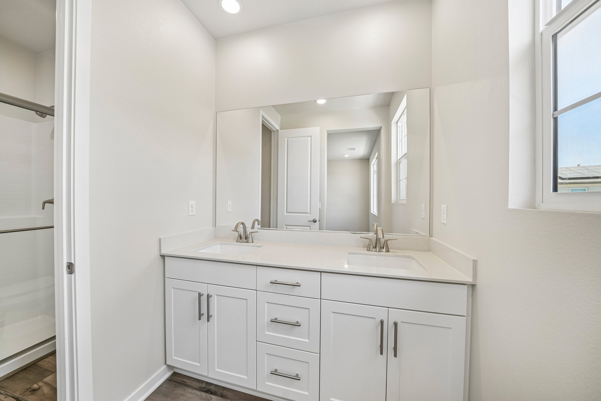A bathroom with white cabinets.