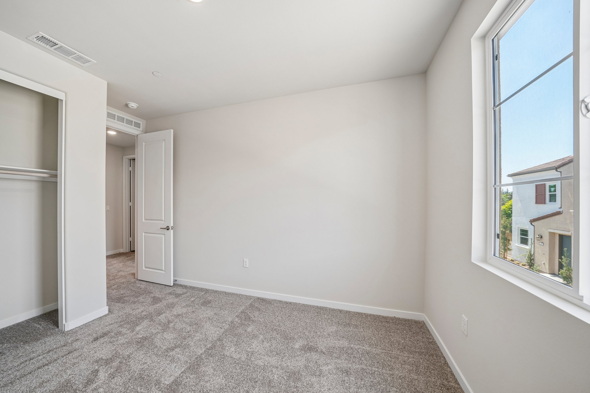 A room with a carpet and windows.