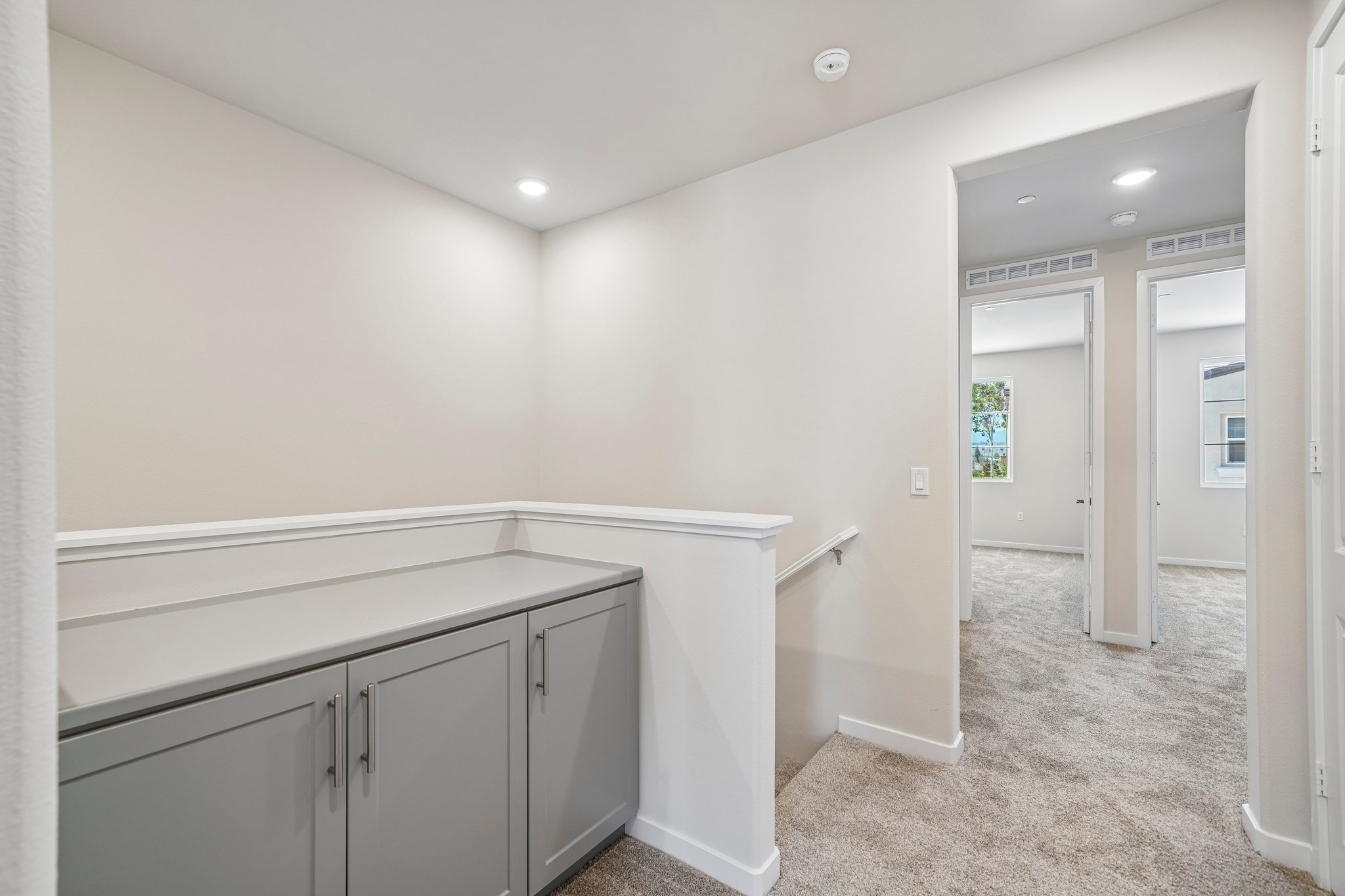 A bathroom with white cabinets.