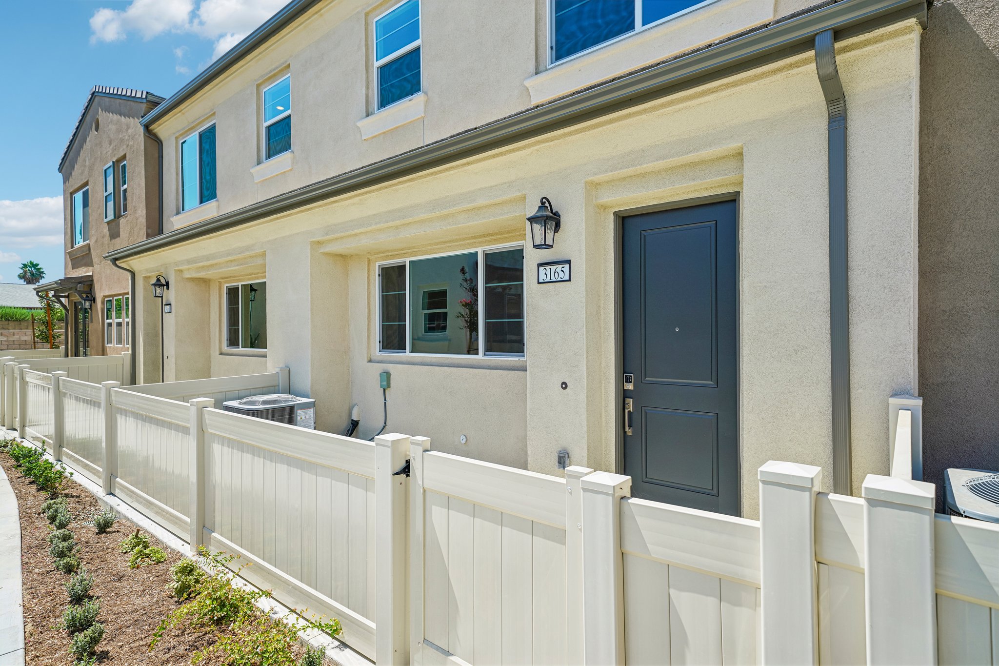 A white fence in front of a house.
