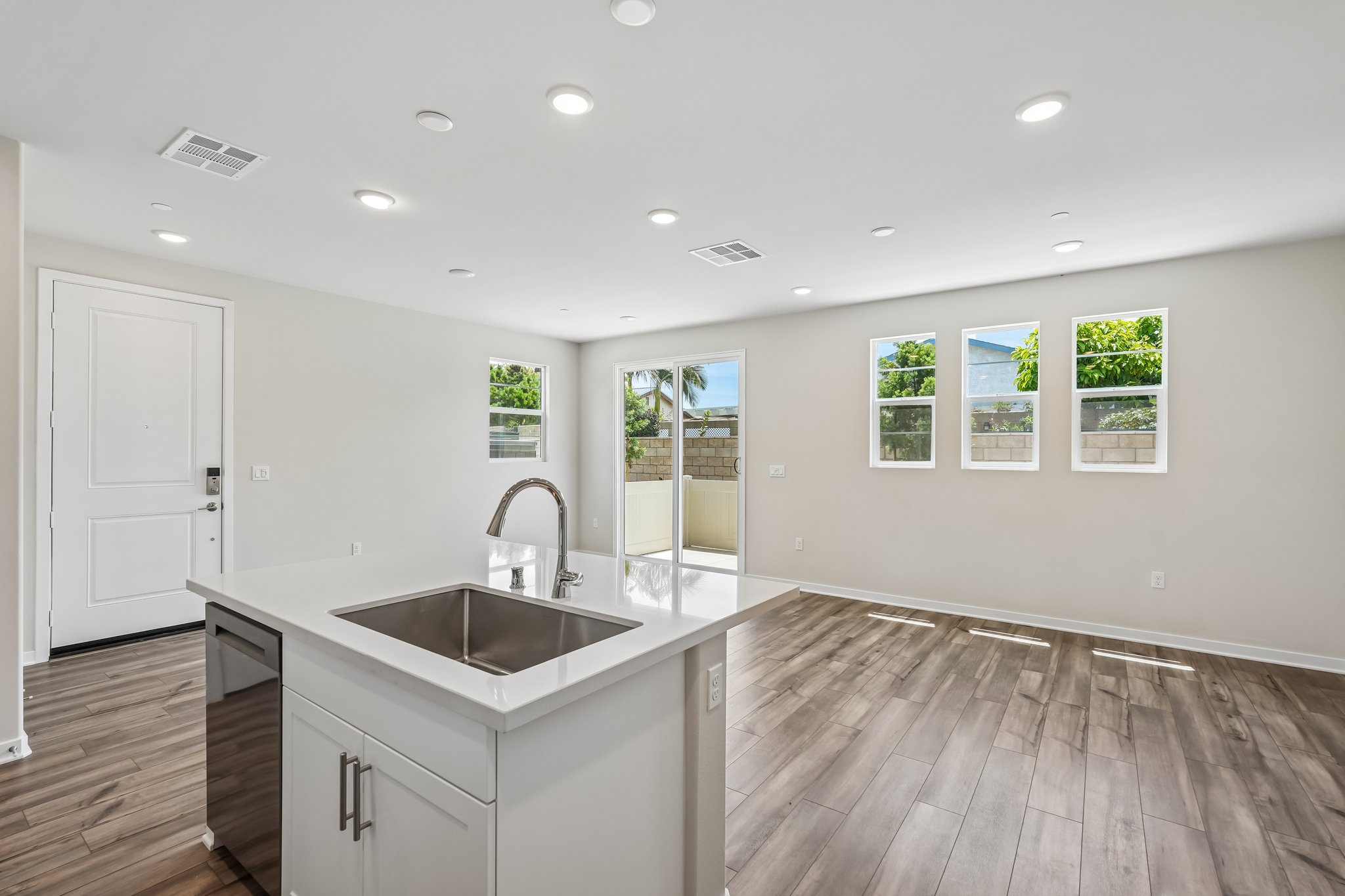 A kitchen with a sink and a large glass door.
