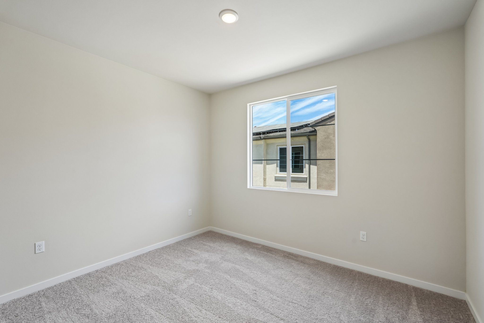 A room with a window and a carpet.