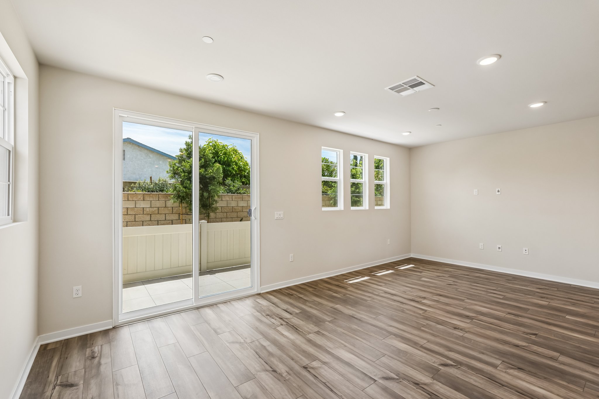 A room with a wood floor and a glass door.