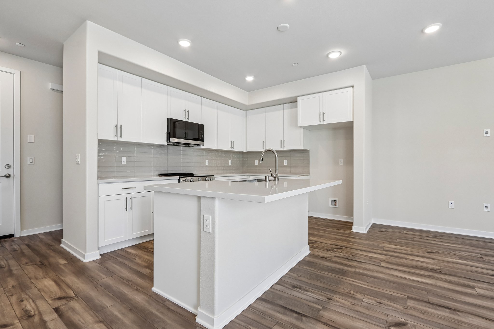 A kitchen with white cabinets.