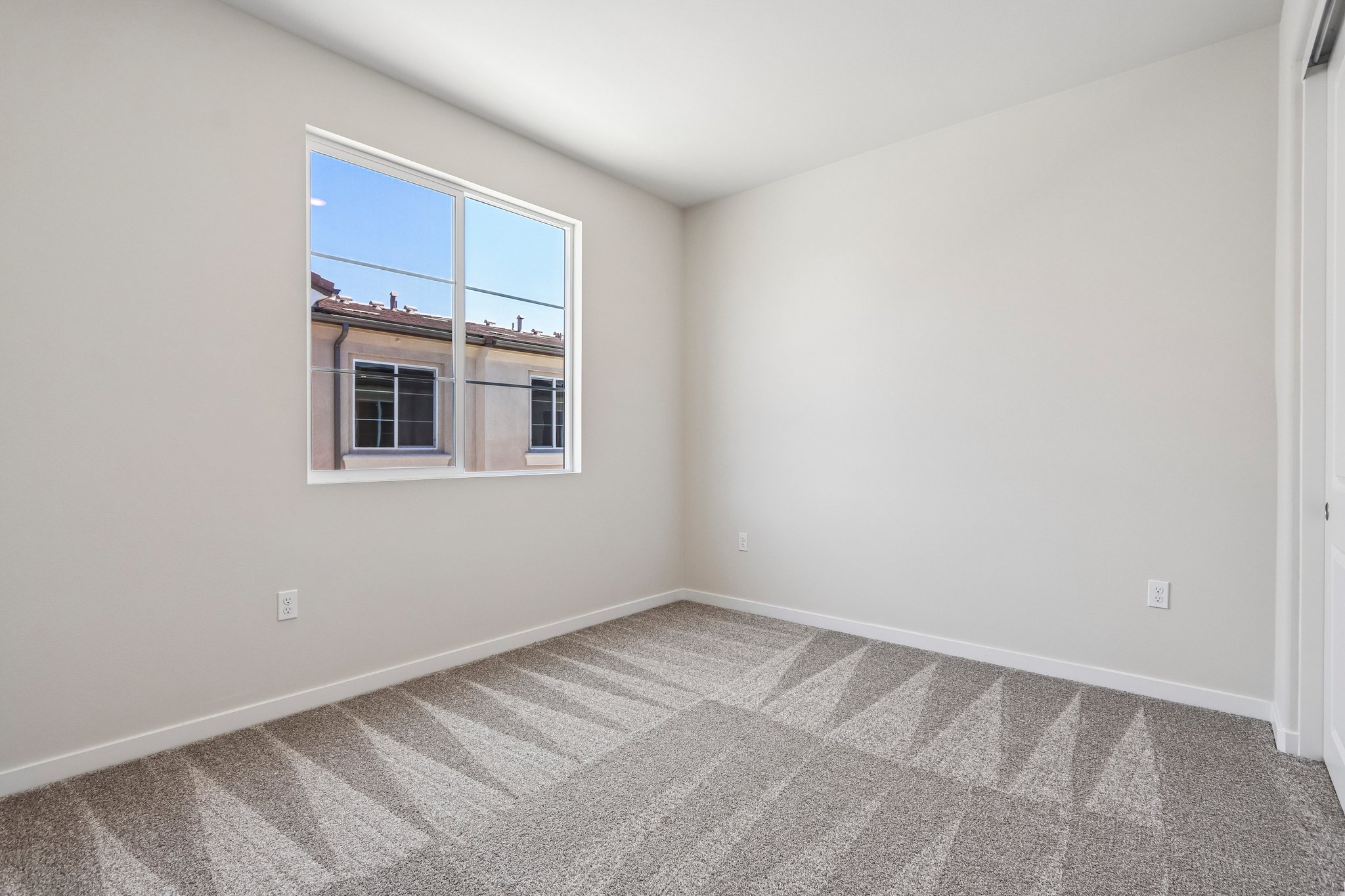 A room with a window and a rug.