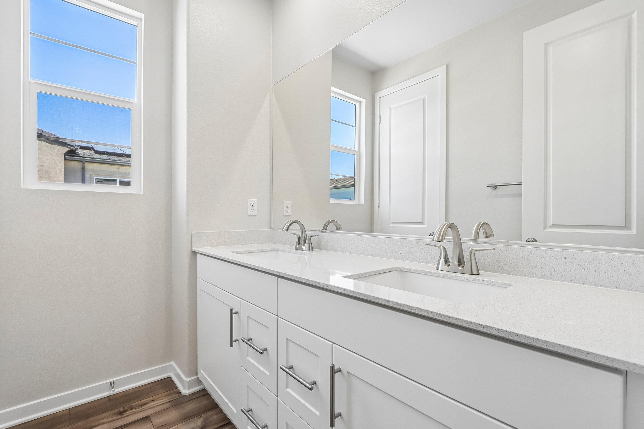 A bathroom with white cabinets.