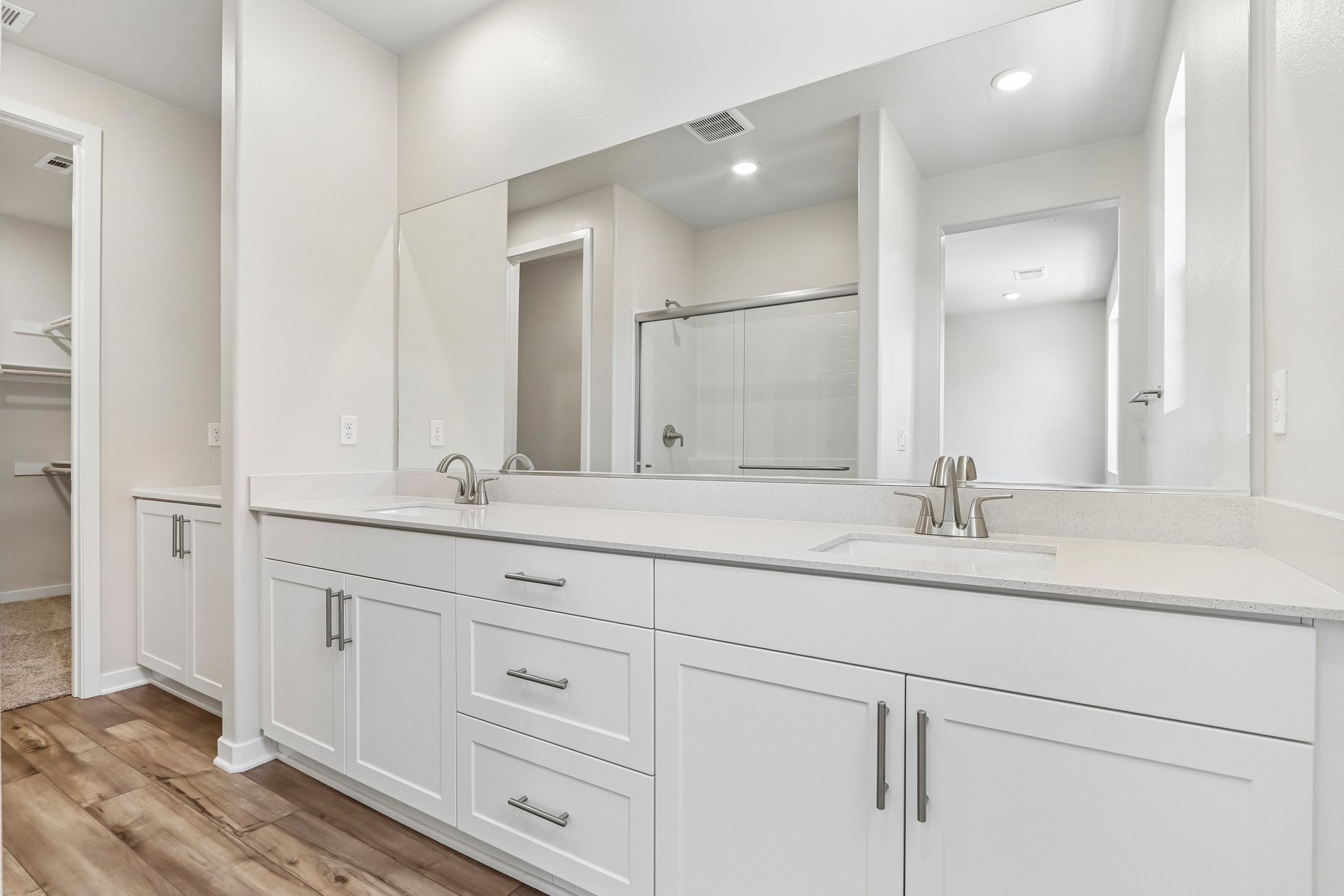 A bathroom with white cabinets.