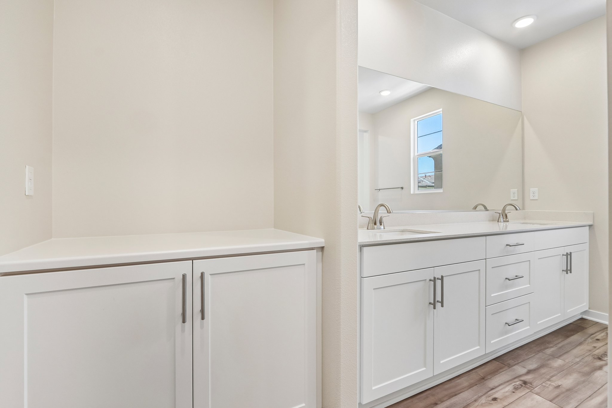 A bathroom with white cabinets.