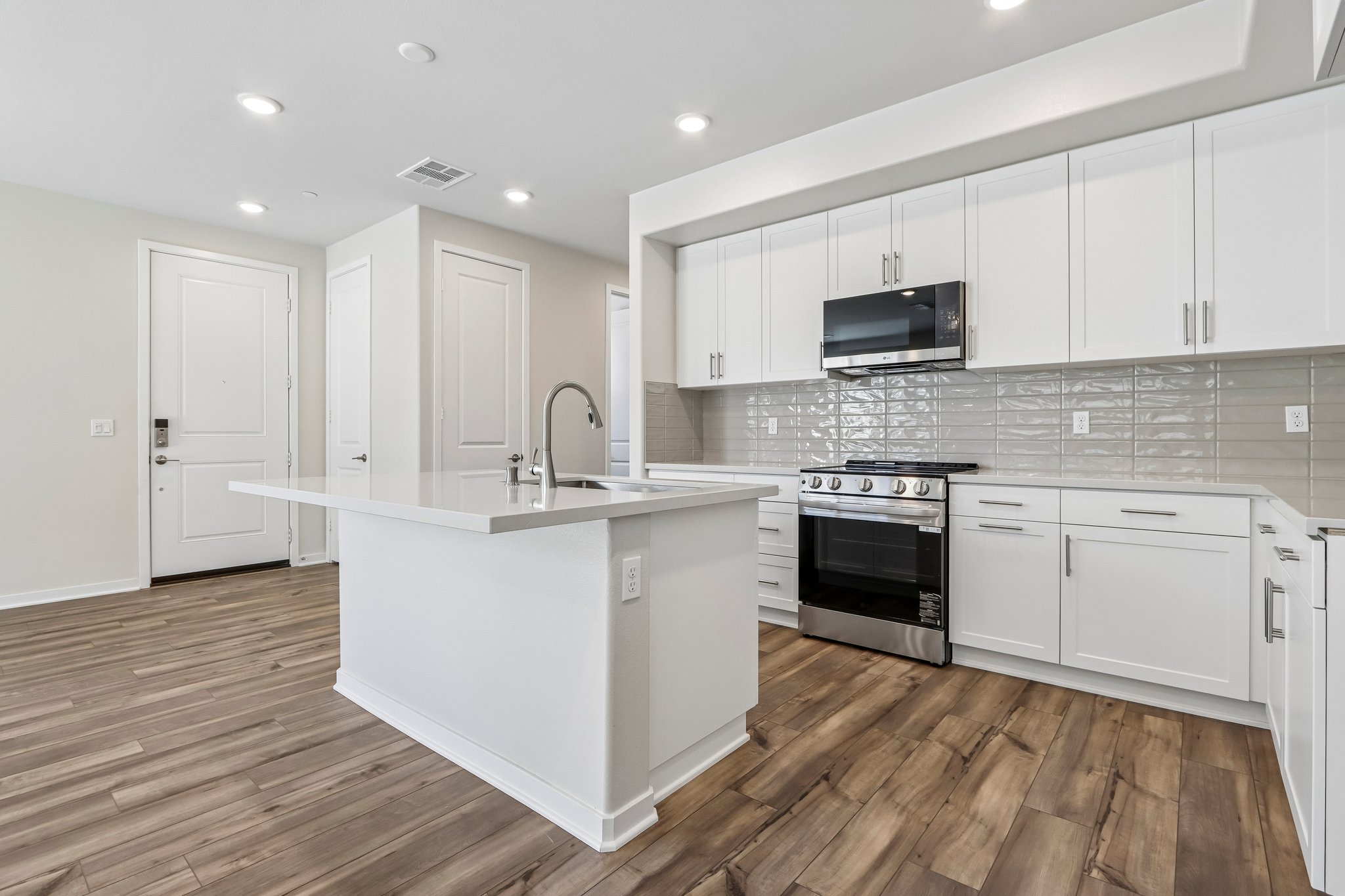 A kitchen with white cabinets.