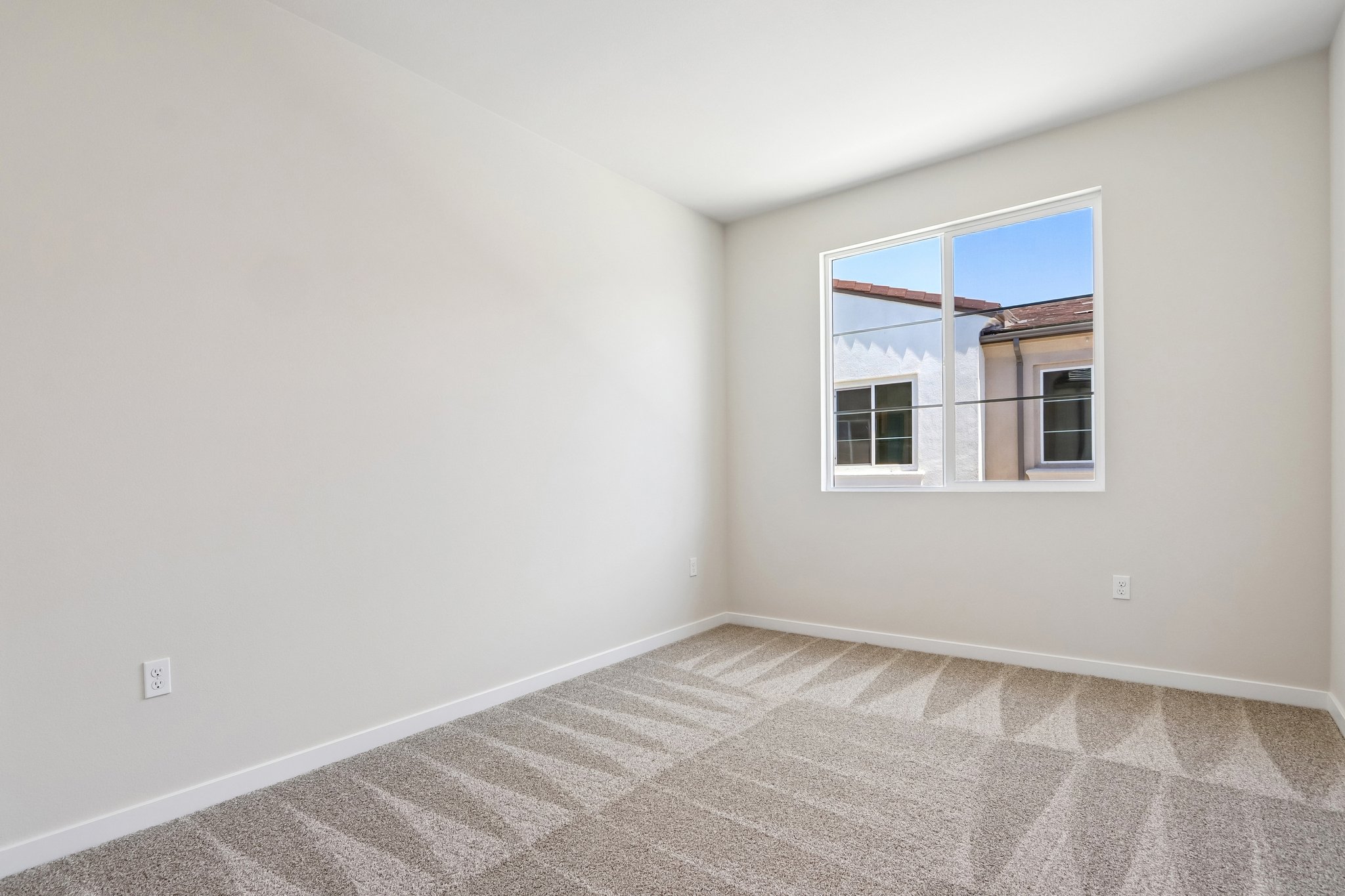 A room with a window and a rug.