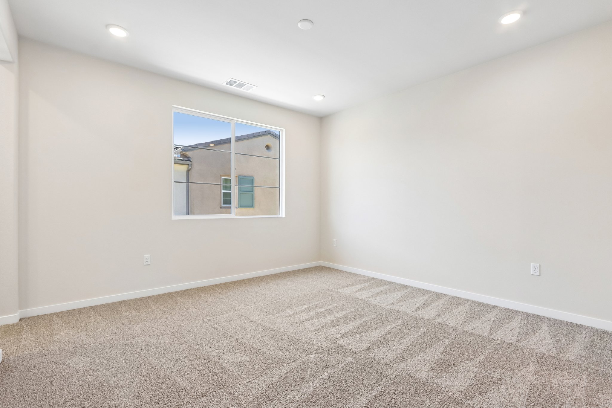 A room with a window and carpet.