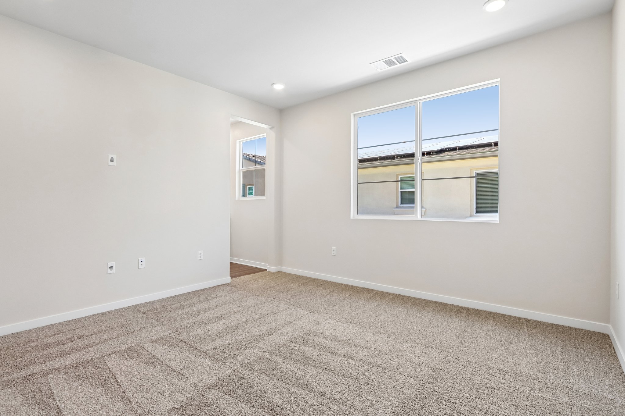 A room with a window and a carpet.