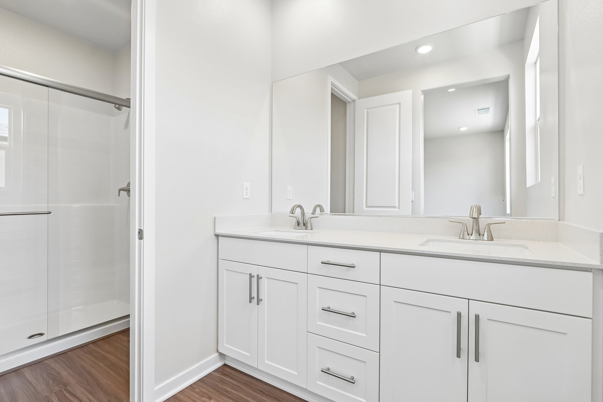 A bathroom with white cabinets.