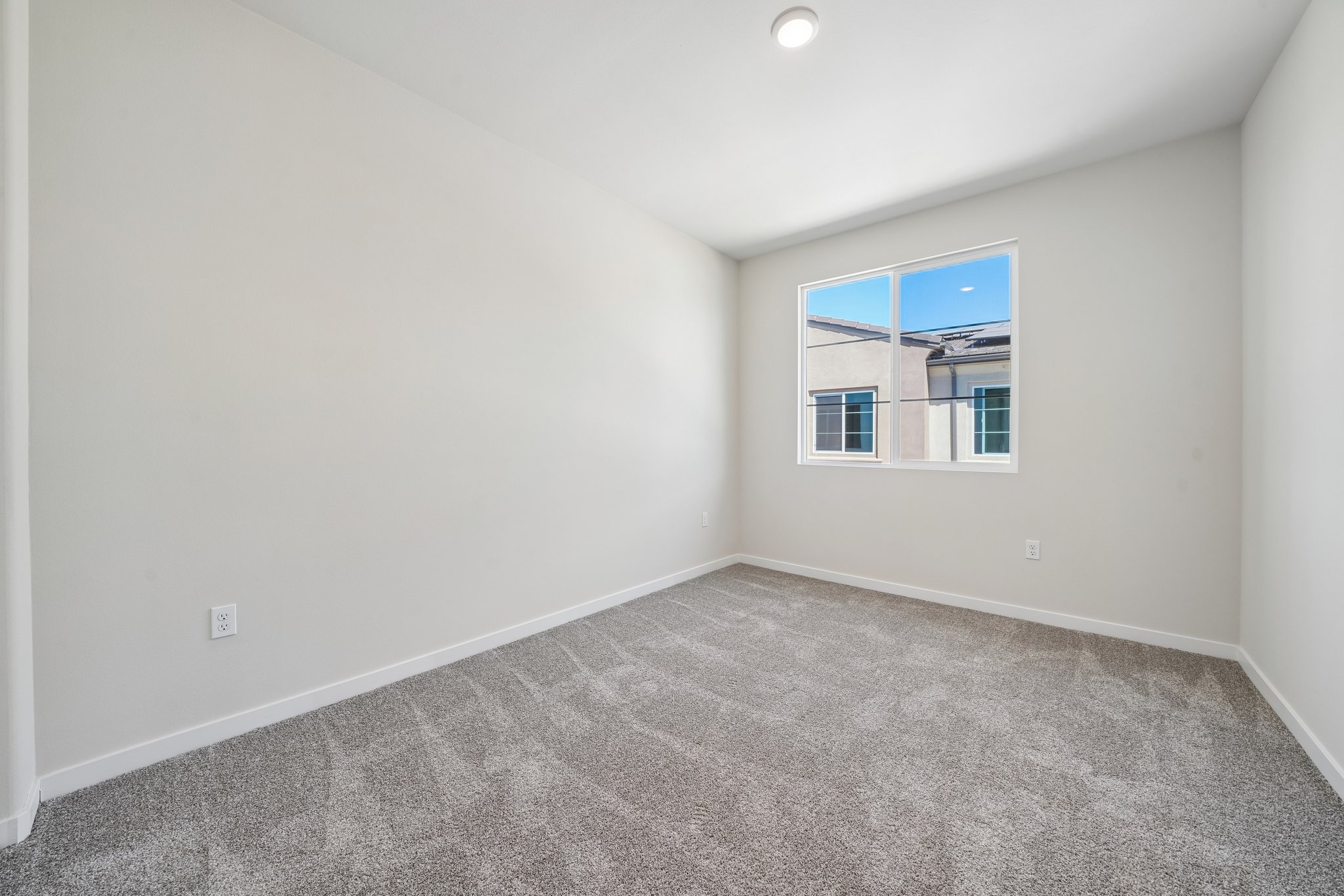 A room with a window and a carpet.