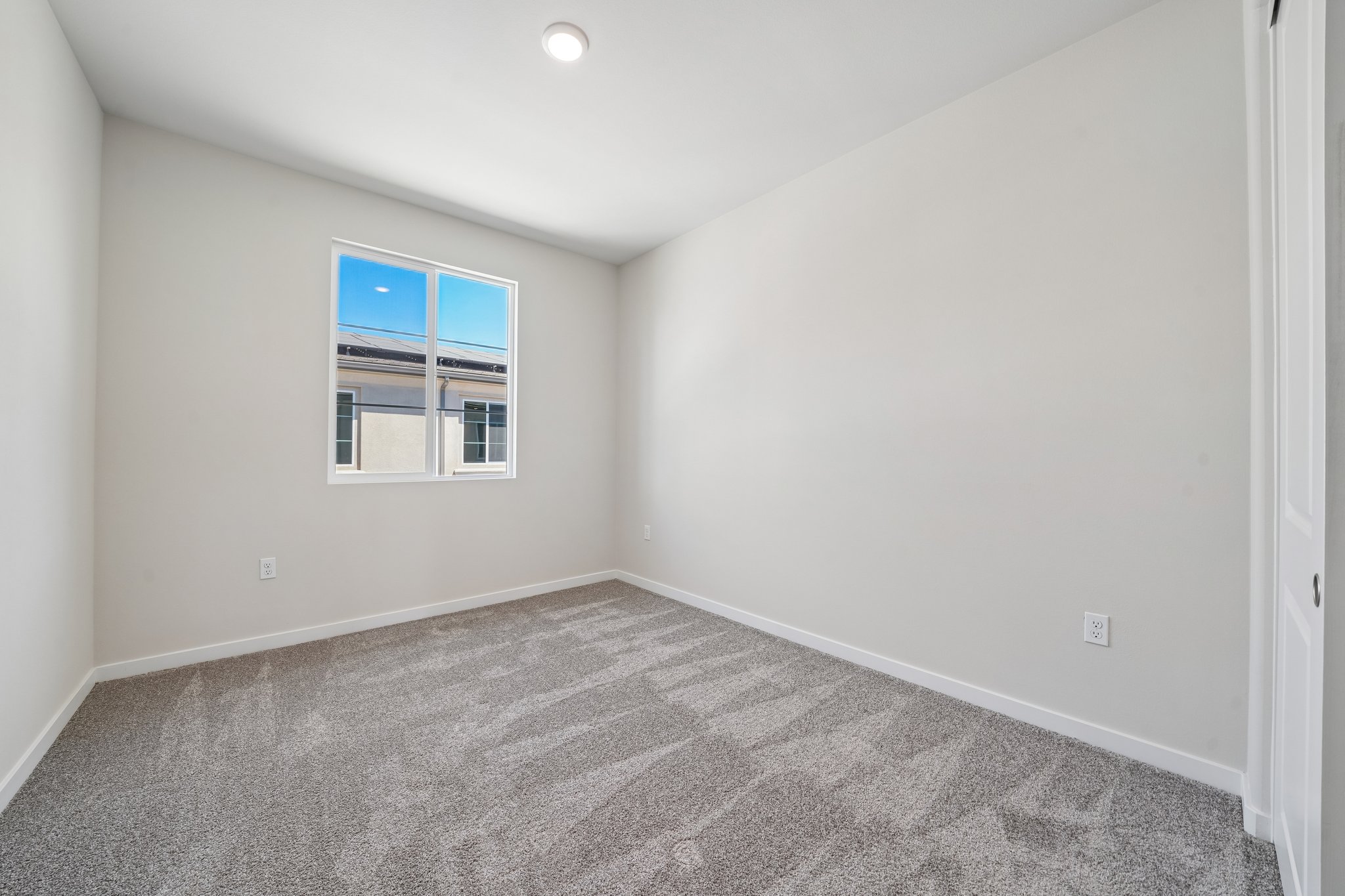 A room with a window and a carpet.