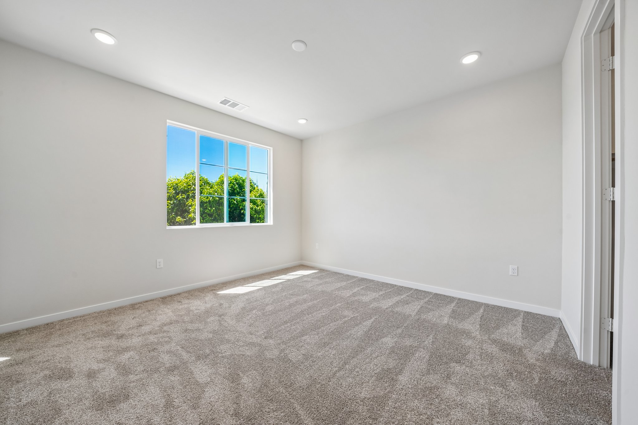 A room with a window and a carpet.