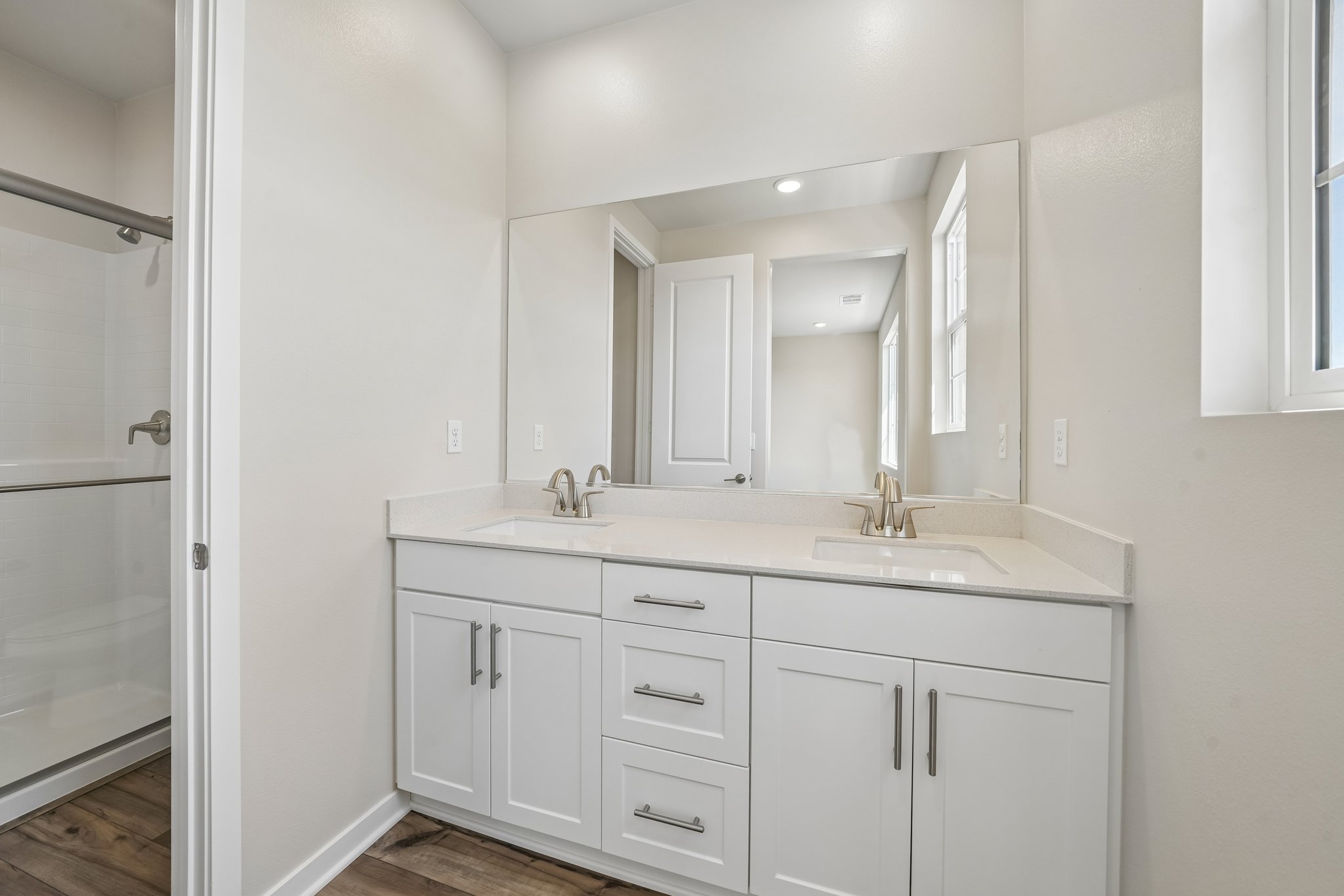 A bathroom with white cabinets.