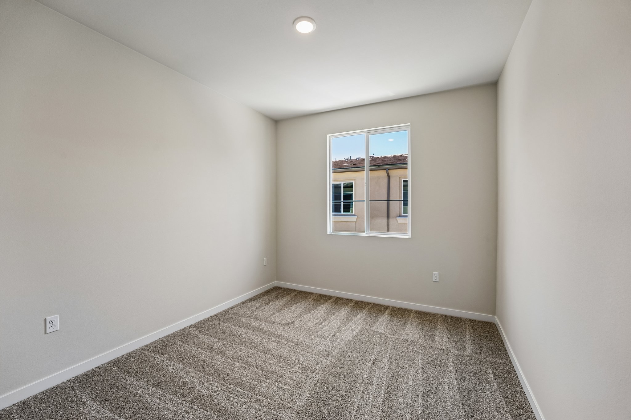 A room with a window and carpet.