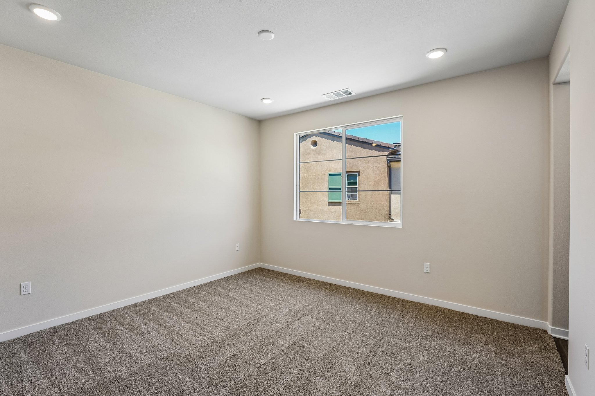A room with a window and a carpet.