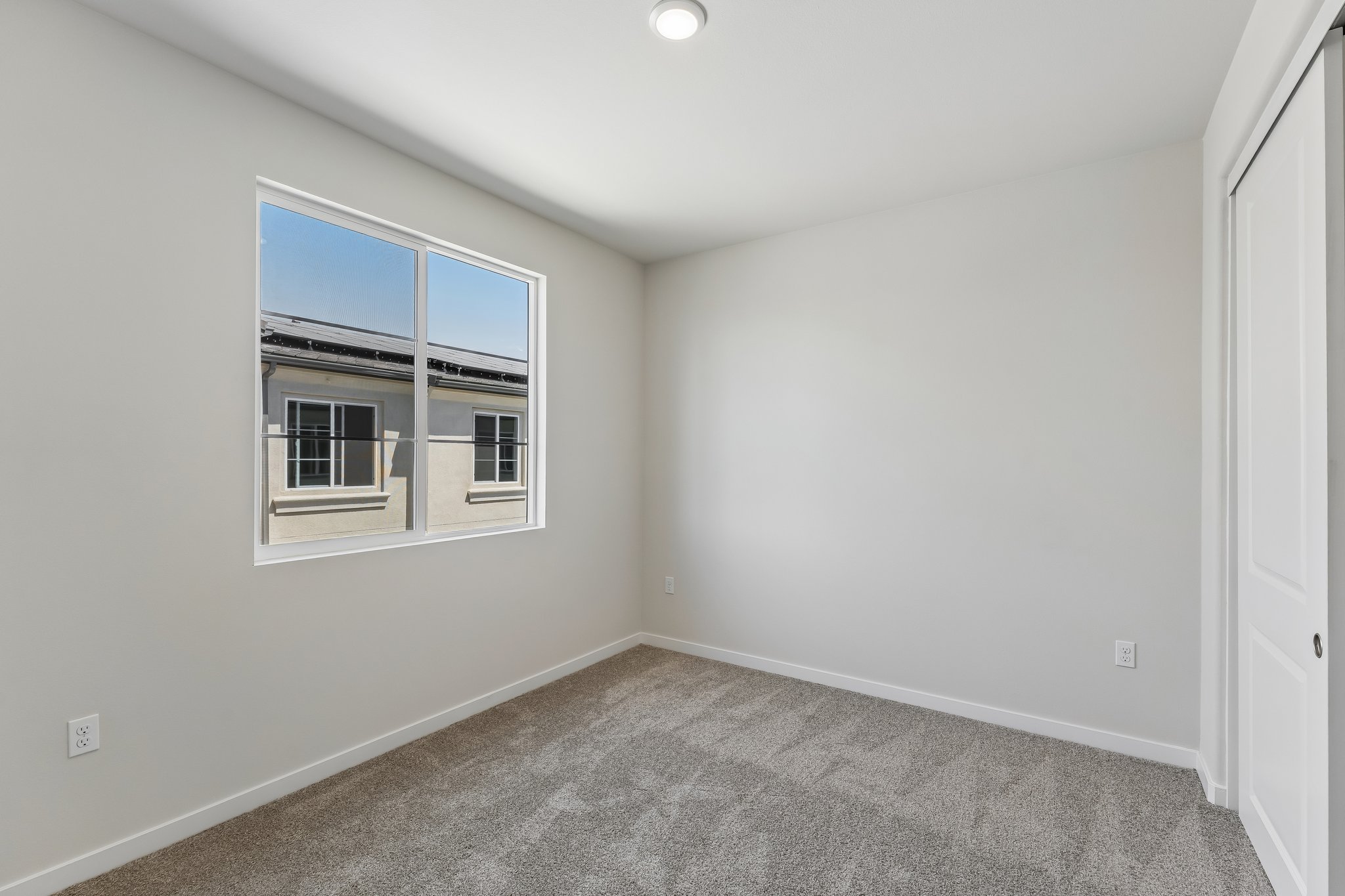 A room with a window and a carpet.